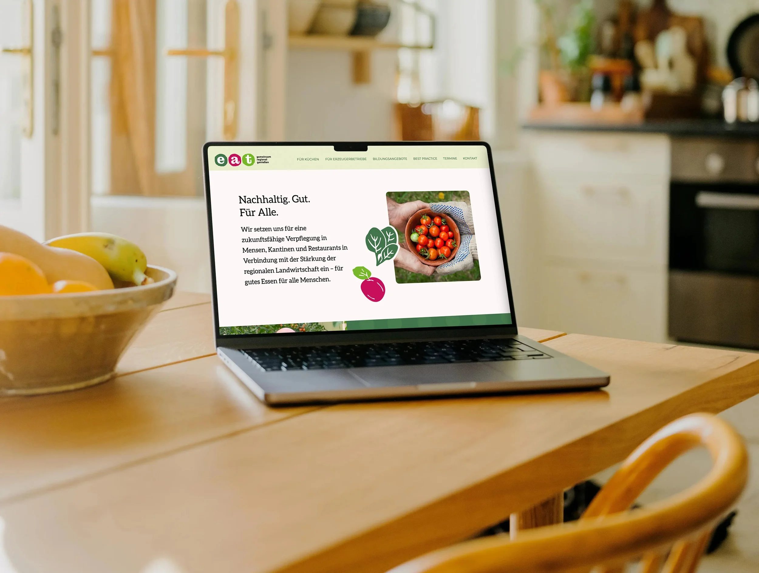 Ein Laptop auf einem Tisch in einer Küche. Auf dem Laptop ist die Website "www.eat-ow.de" geöffnet.