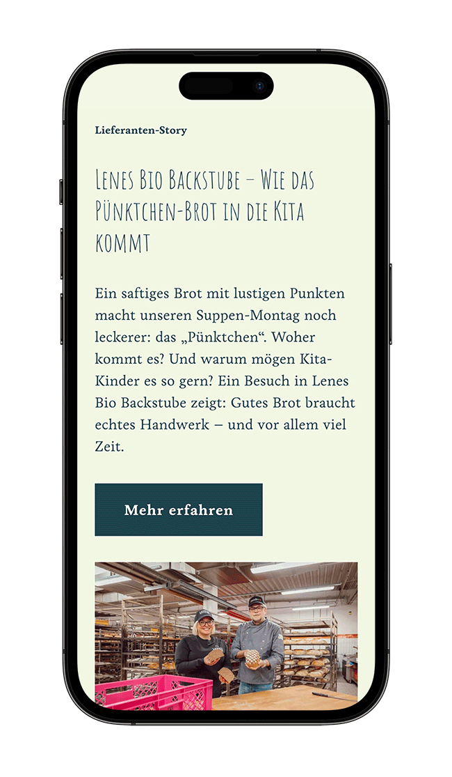 Smartphone zeigt eine Webseite über die Herstellung von Punktchenbrot in einer Bäckerei, mit einem Bild von zwei Bäckern, die Brote im Backraum halten.