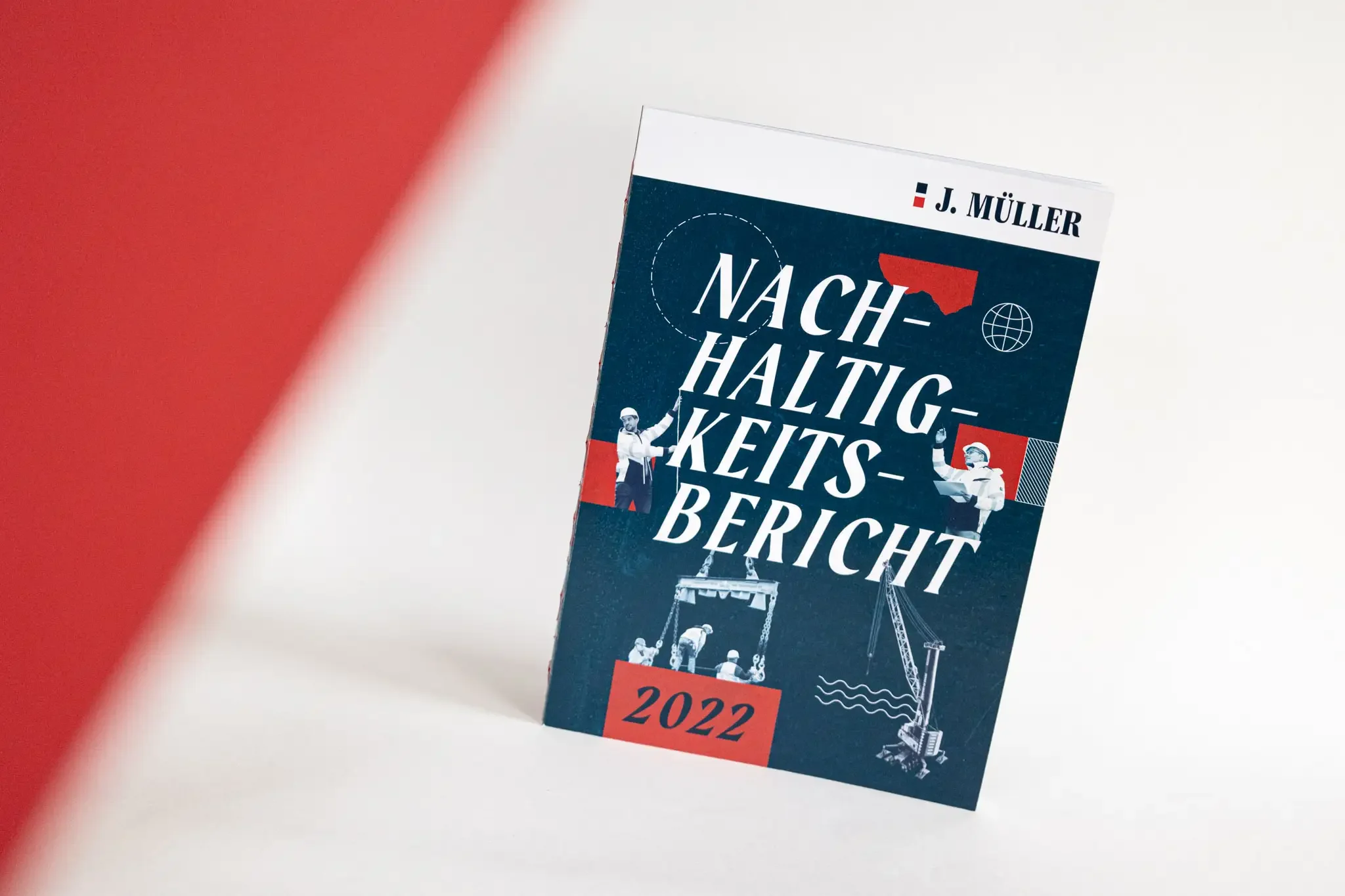 Ein Foto einer Broschüre mit collagenartigen Bildern die Hafenmitarbeiter und Hafengerät von J.Müller zeigen. Auf der Broschüre steht der Text "Nachhaltigkeitsbericht 2022"