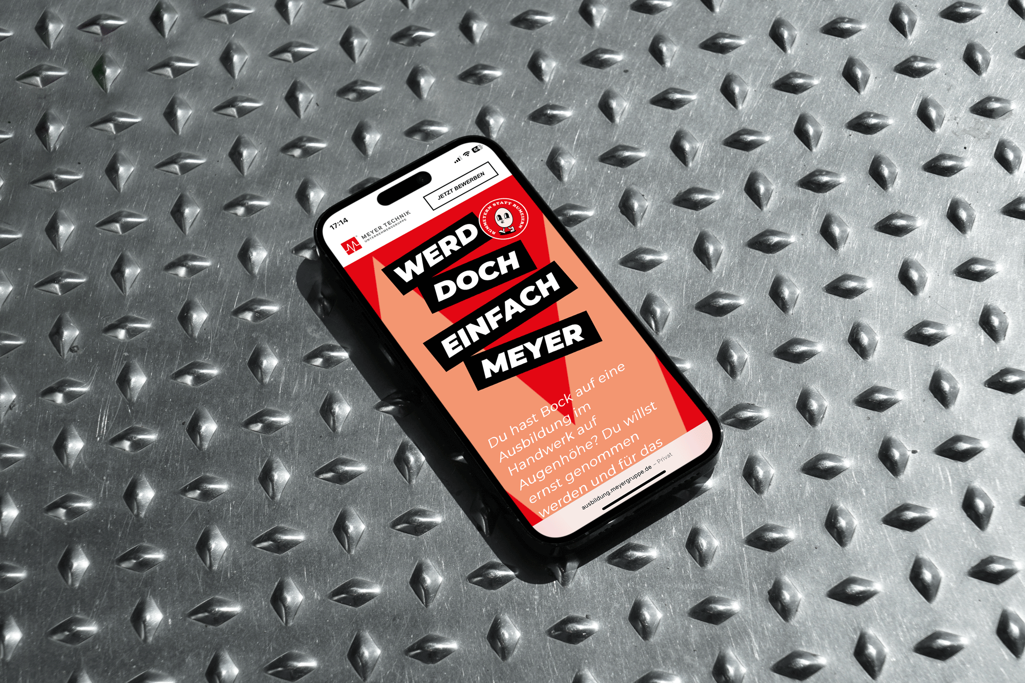 Ein Smartphone auf einem Metallhintergrund, auf dem Smartphone ist die Azubiwebsite geöffnet.