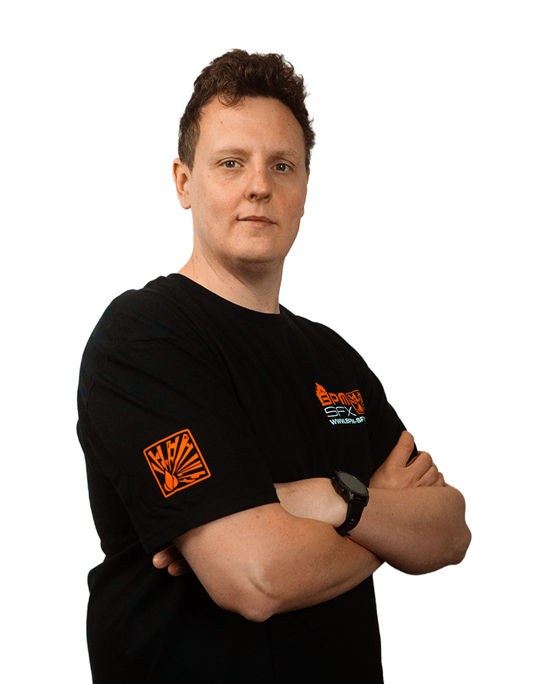 A man with short curly hair standing with arms crossed, wearing a black t-shirt with orange and white logo and text, and a black wristwatch.