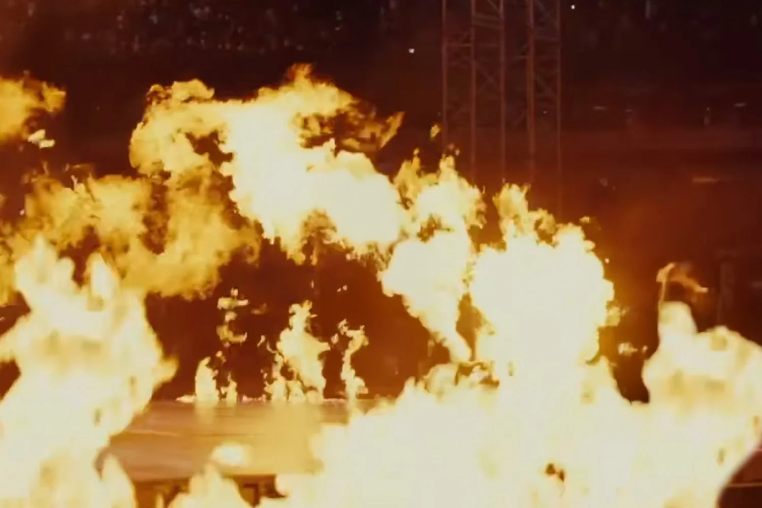 Explosion with large flames and fireballs on a dark night.