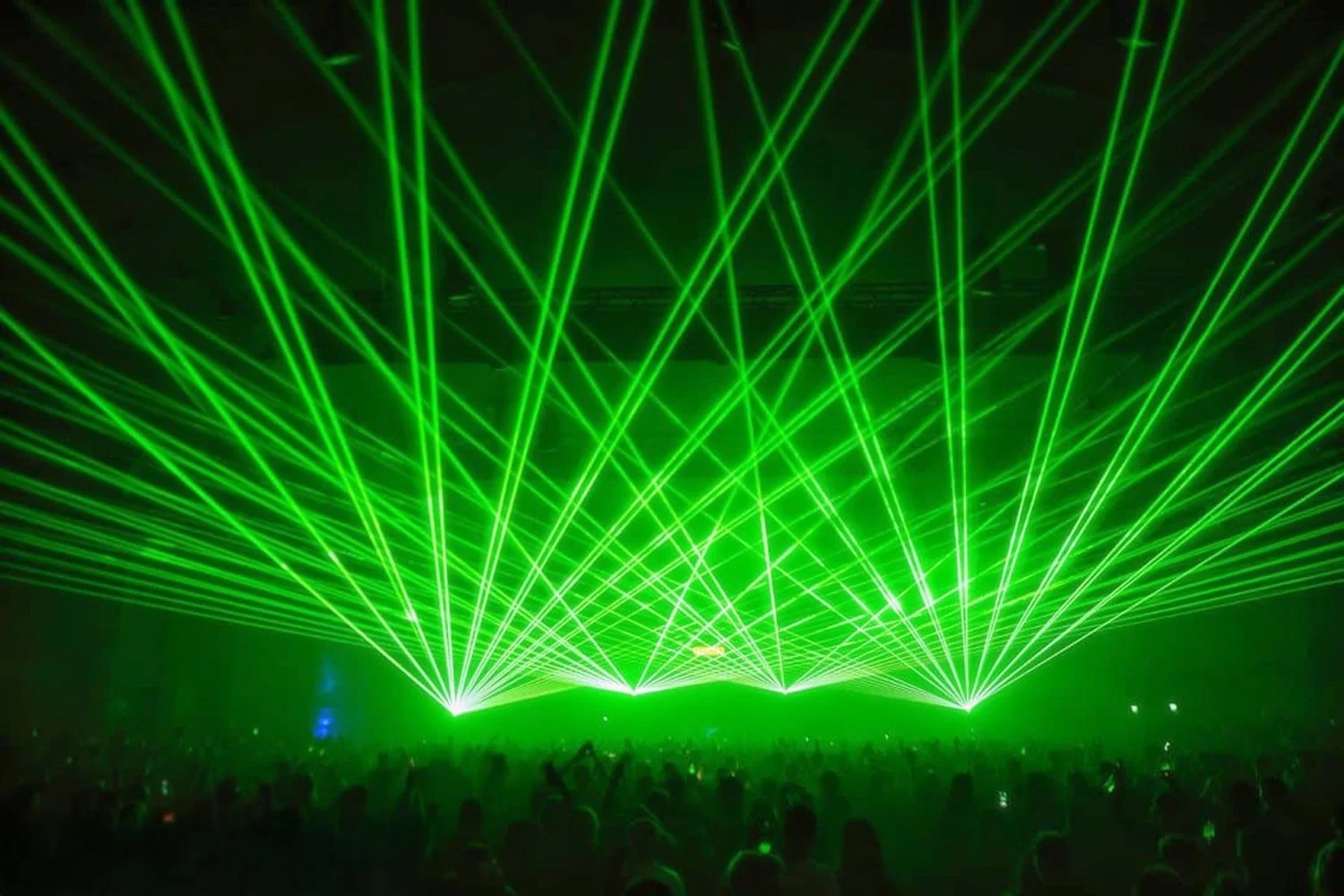 Green laser light show over a crowd at a concert or event.