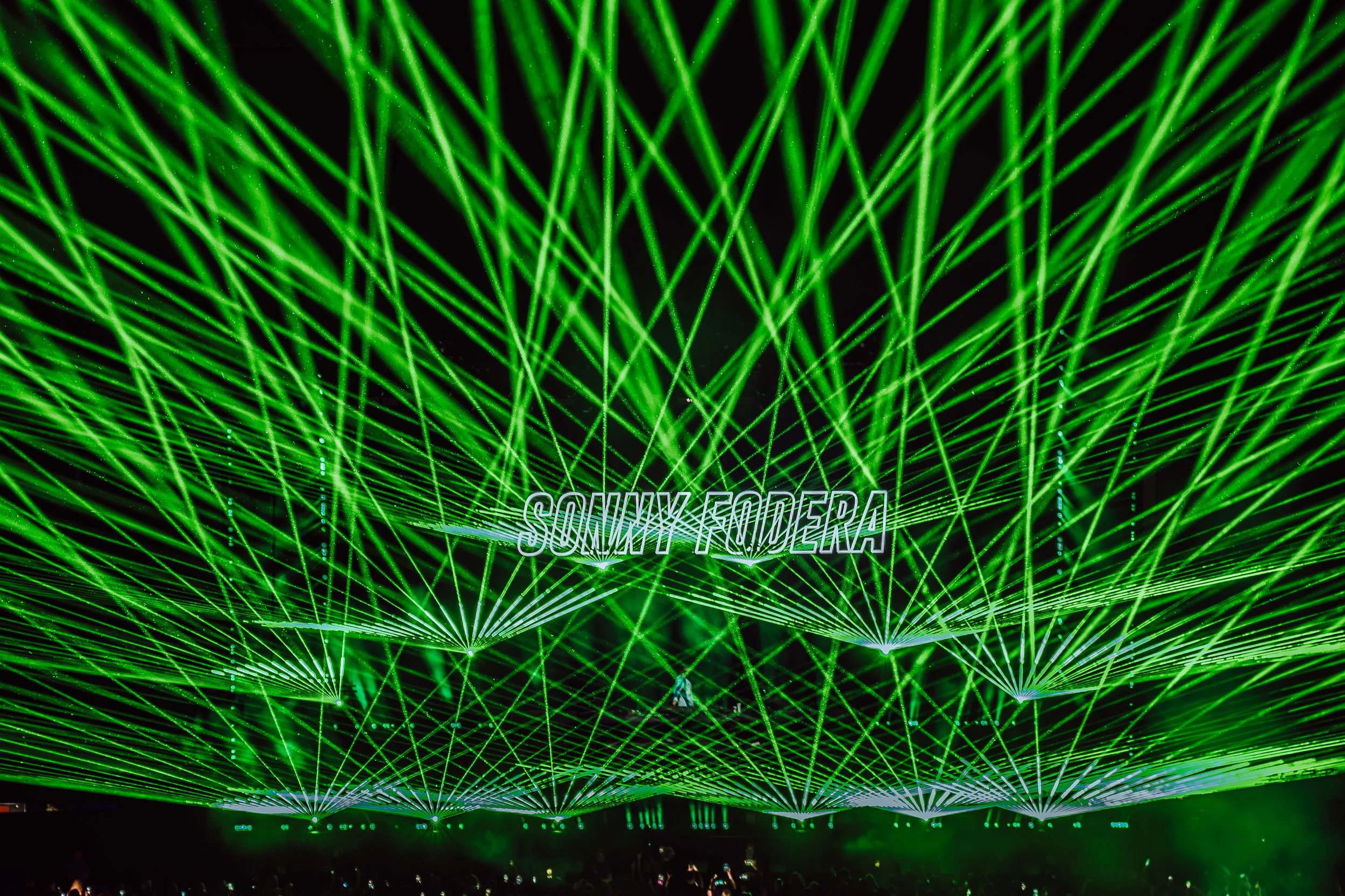 Green laser light show with intersecting beams and the words 'SOMIK FODER' displayed in the center.