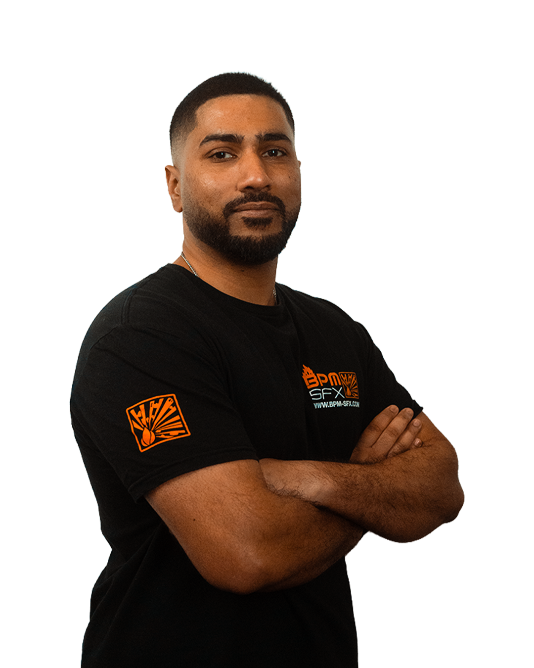 Confident man with crossed arms wearing a black t-shirt with logos, standing against a plain background.