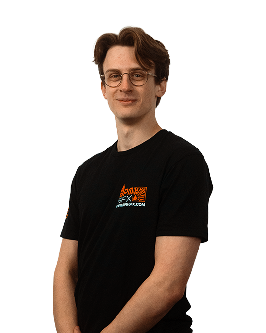 A young man with glasses and brown hair, wearing a black T-shirt with a logo, standing and smiling at the camera.