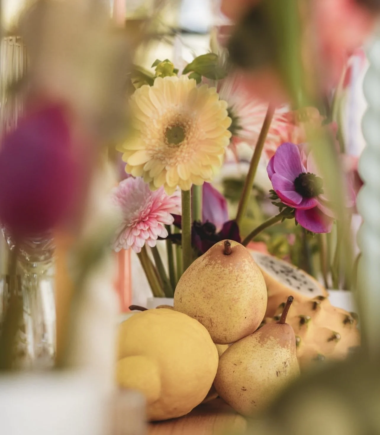 Un arrangement de fleurs colorées avec des poires et des morceaux de fruit tropical