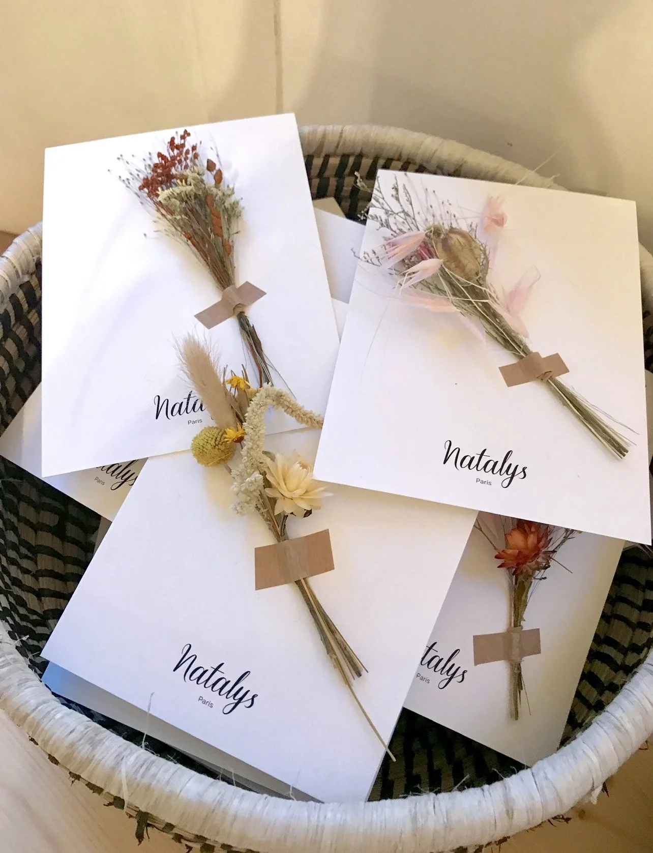 Carton avec des bouquets de fleurs en papier et message 'Natalys Paris'