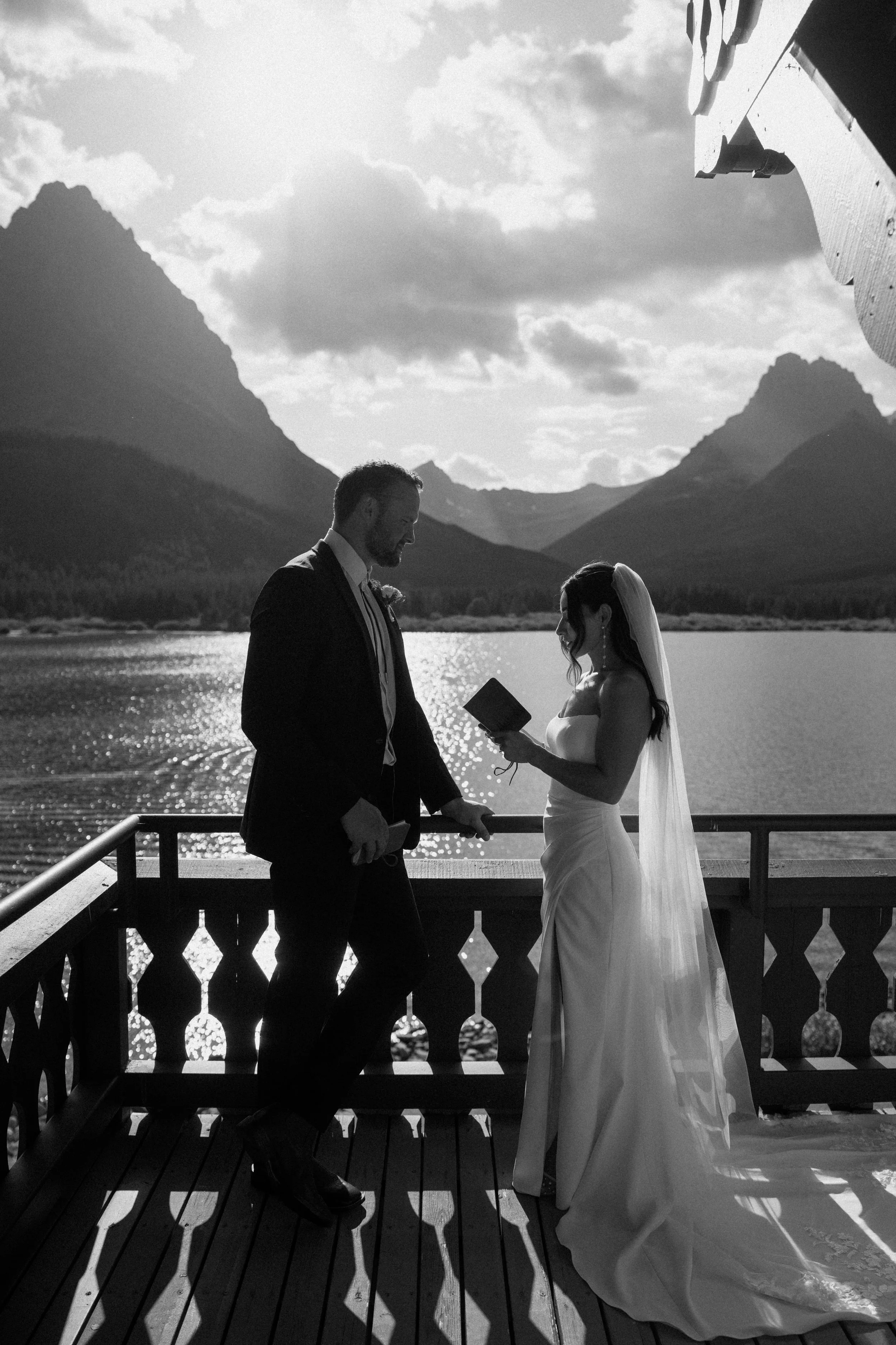 Intimate outdoor elopement ceremony in Glacier National Park with couple exchanging vows at Many Glacier Hotel