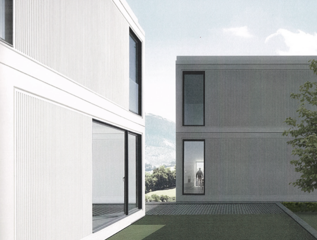 Vista de edificios modernos con ventanas grandes y un área de césped, en un día soleado con algunas nubes.