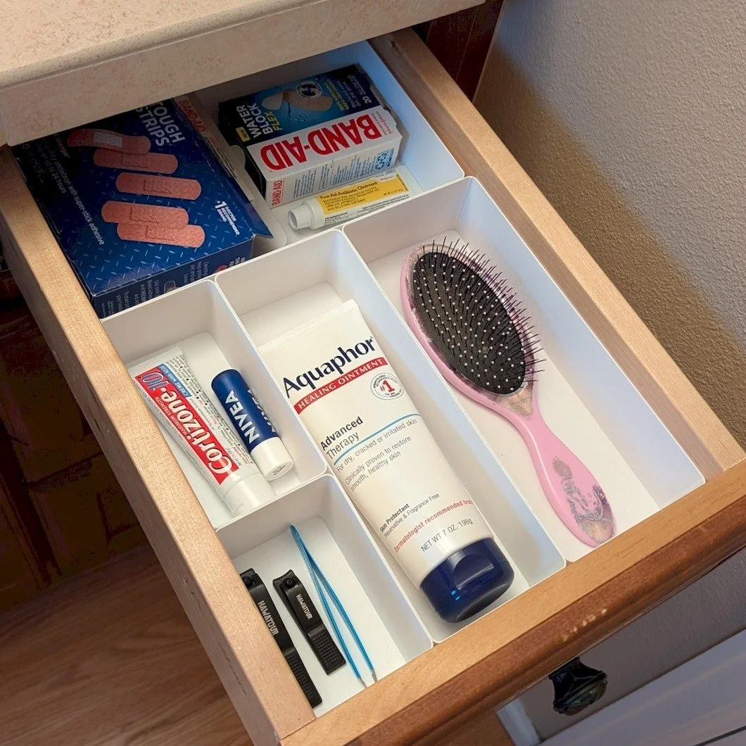 Open drawer with white custom bins to maximize available bathroom storage space