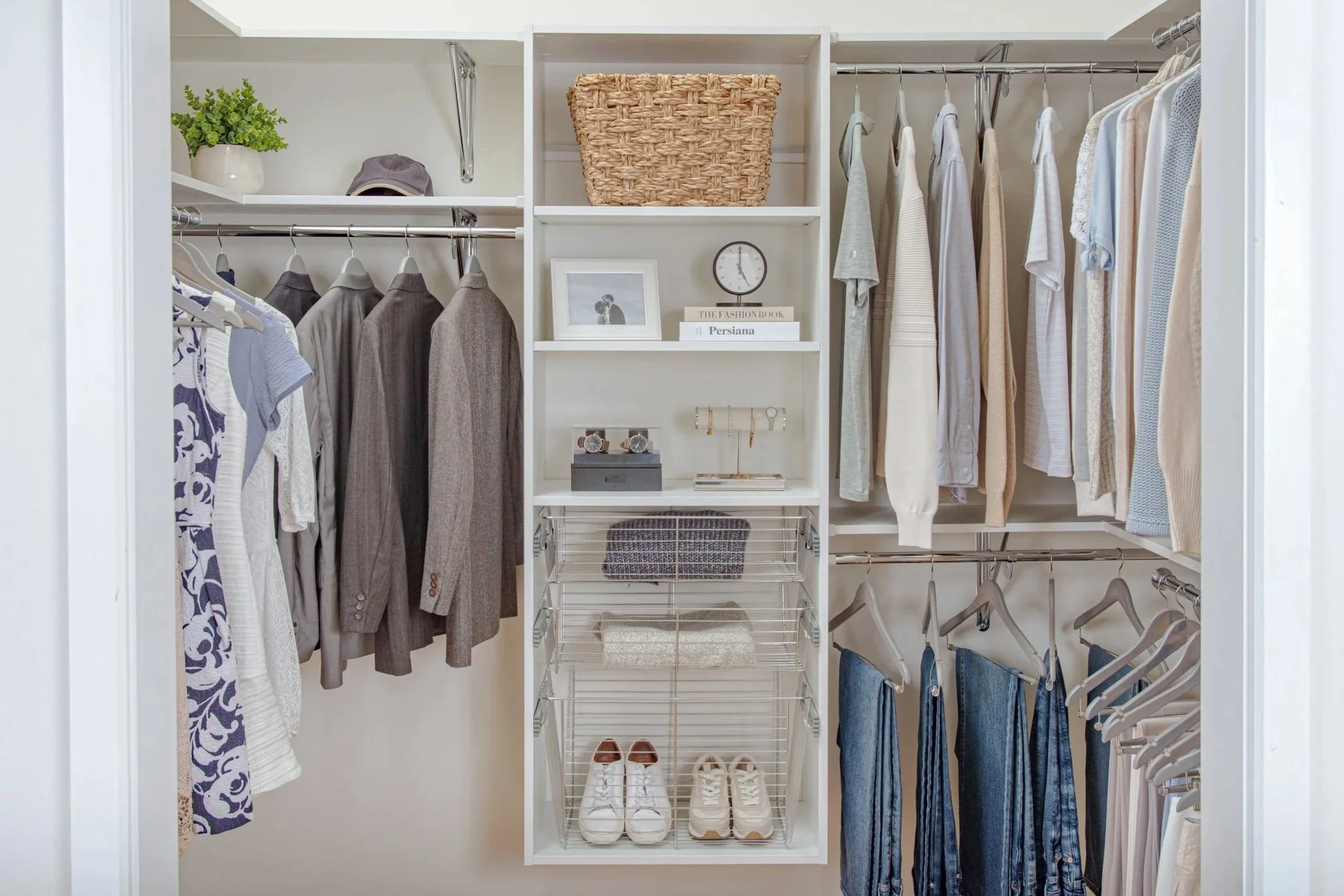 Walk-in closet with fixed shelves, hanging rods and a storage tower with adjustable shelves and chrome basket-style drawers