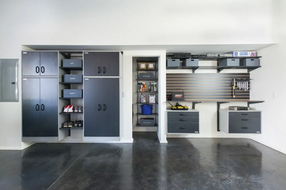 Modern organized garage with storage cabinets, drawers, shelves, and tools on a pegboard