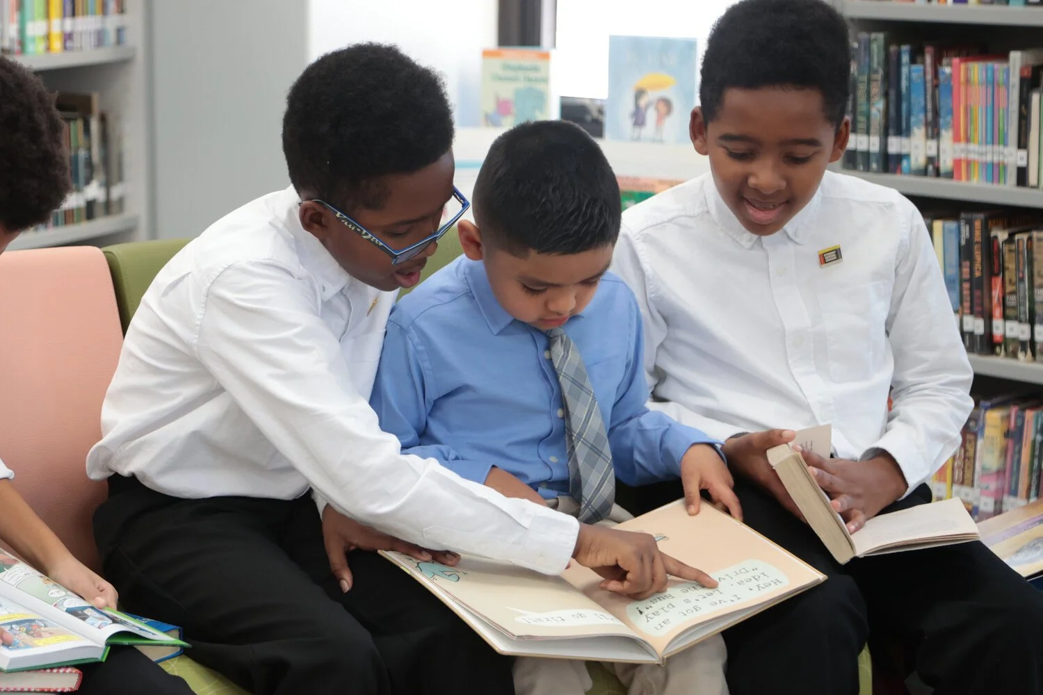   Matthew and Jacob Reyes read to Cagen Montesinos inside the new library space.    