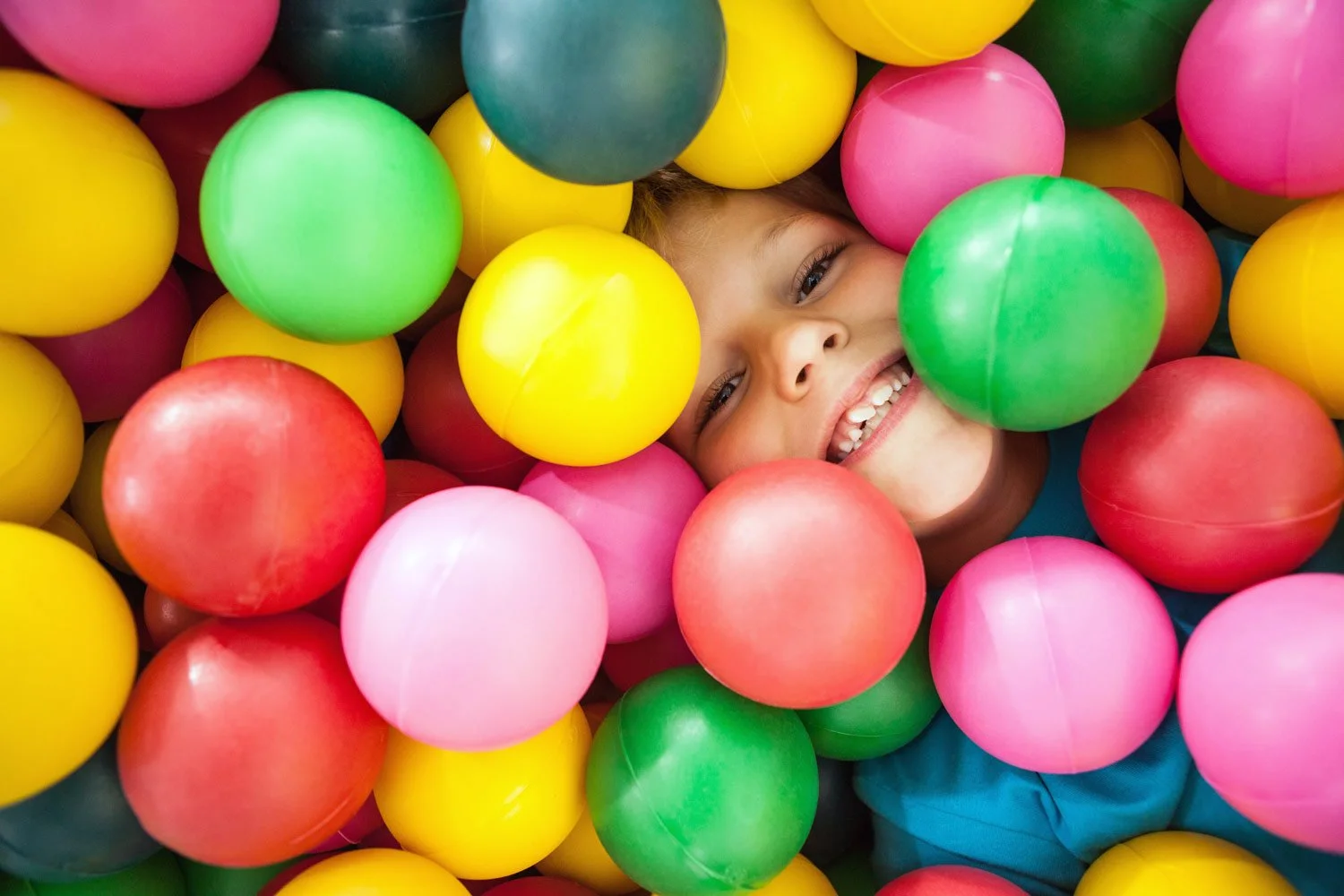 Kid in ball pool smiling