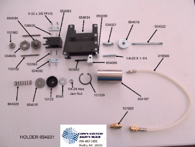 Disassembled mechanical or electronic component with various metal, plastic, and rubber parts, labeled with part numbers. Includes a black housing, screws, springs, fittings, a flexible cable, and a sticker from Converter Services.