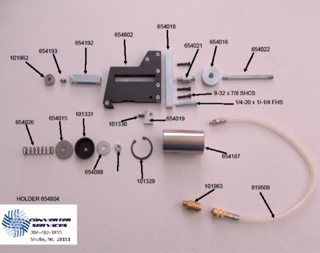 Disassembled mechanical or electronic device parts laid out on a surface, including metal, plastic, wiring, and small screws, with label annotations.