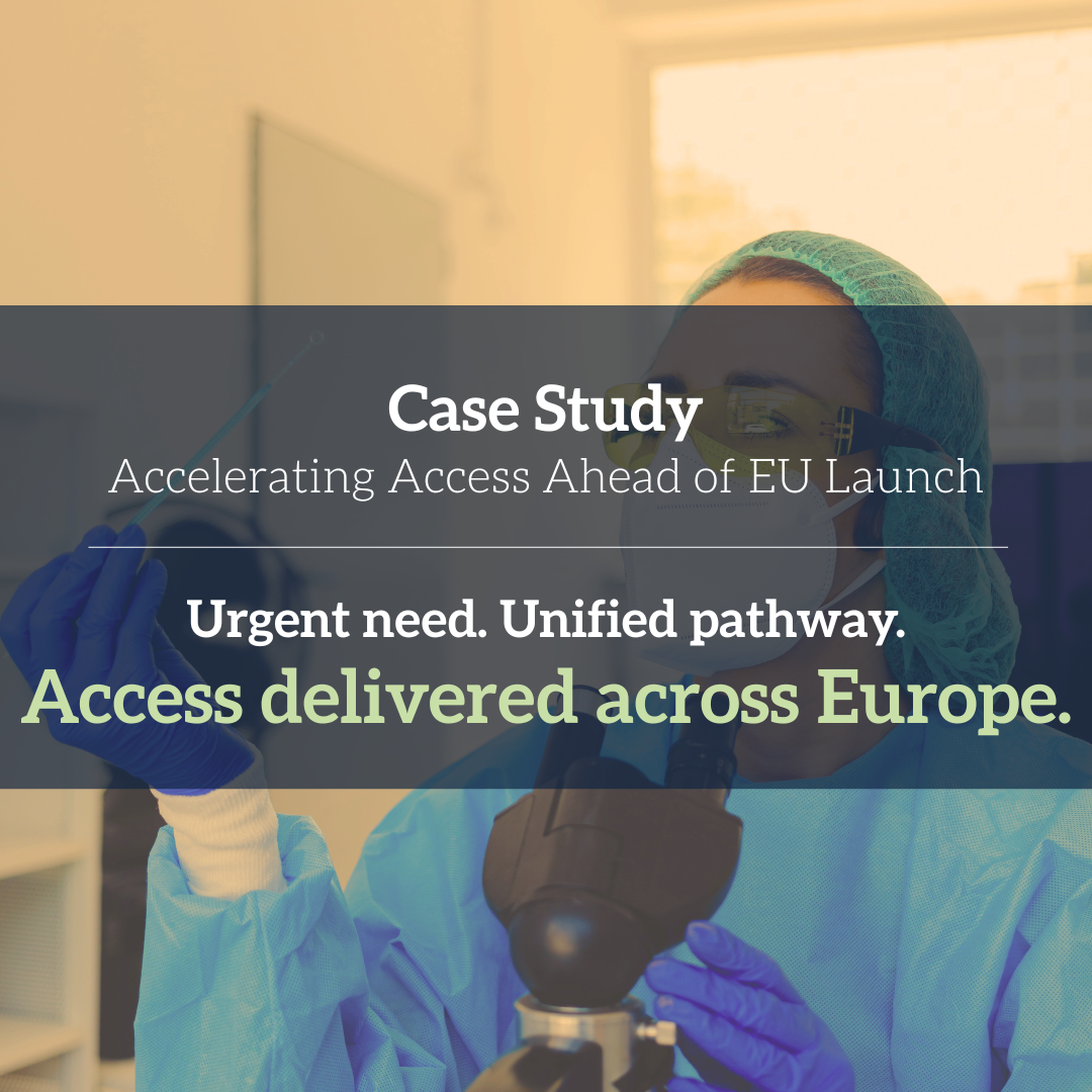 A scientist in protective gear looking through a microscope in a laboratory.