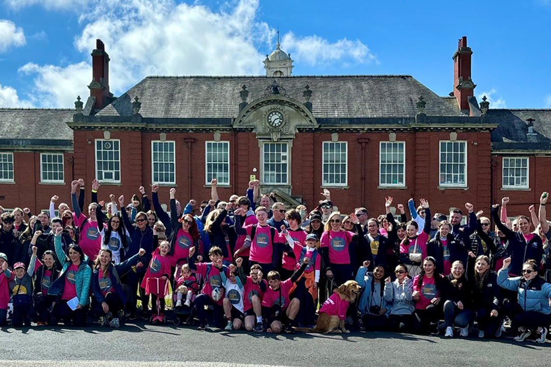 A photograph depicting a large group of people wearing custom screen-printed t-shirts.