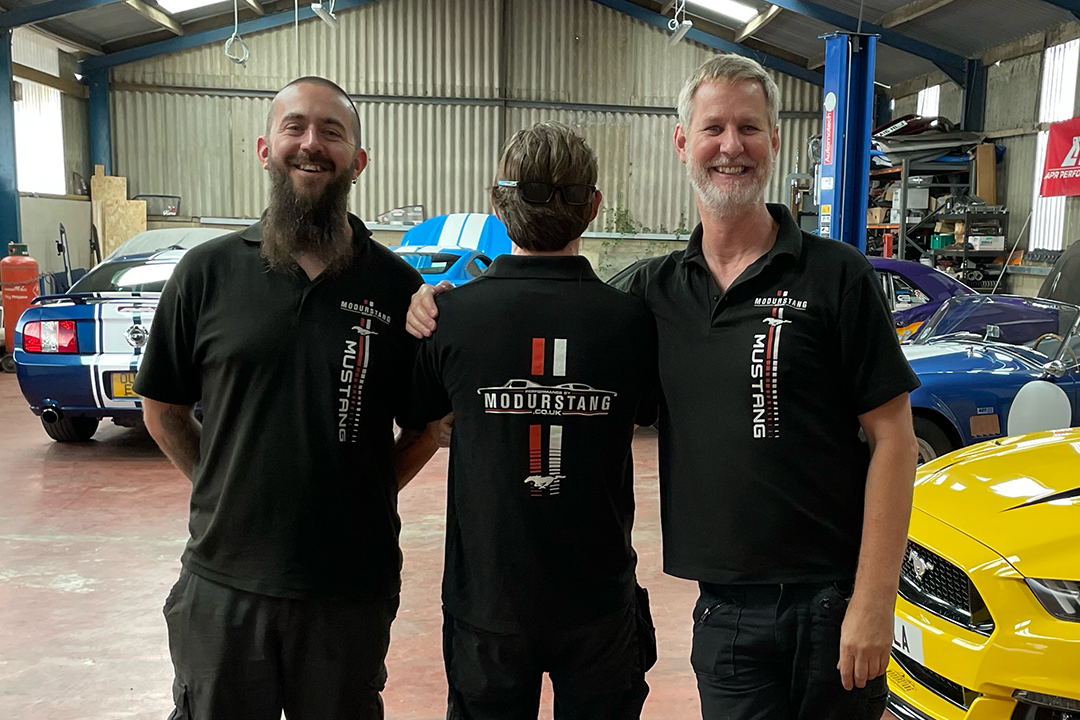 A photograph of men with happy expressions, wearing custom branded polo shirts.