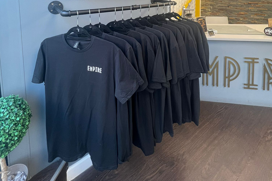 A photograph showing a set of custom clothing for Empire Tattoo Studio on a clothes rail.