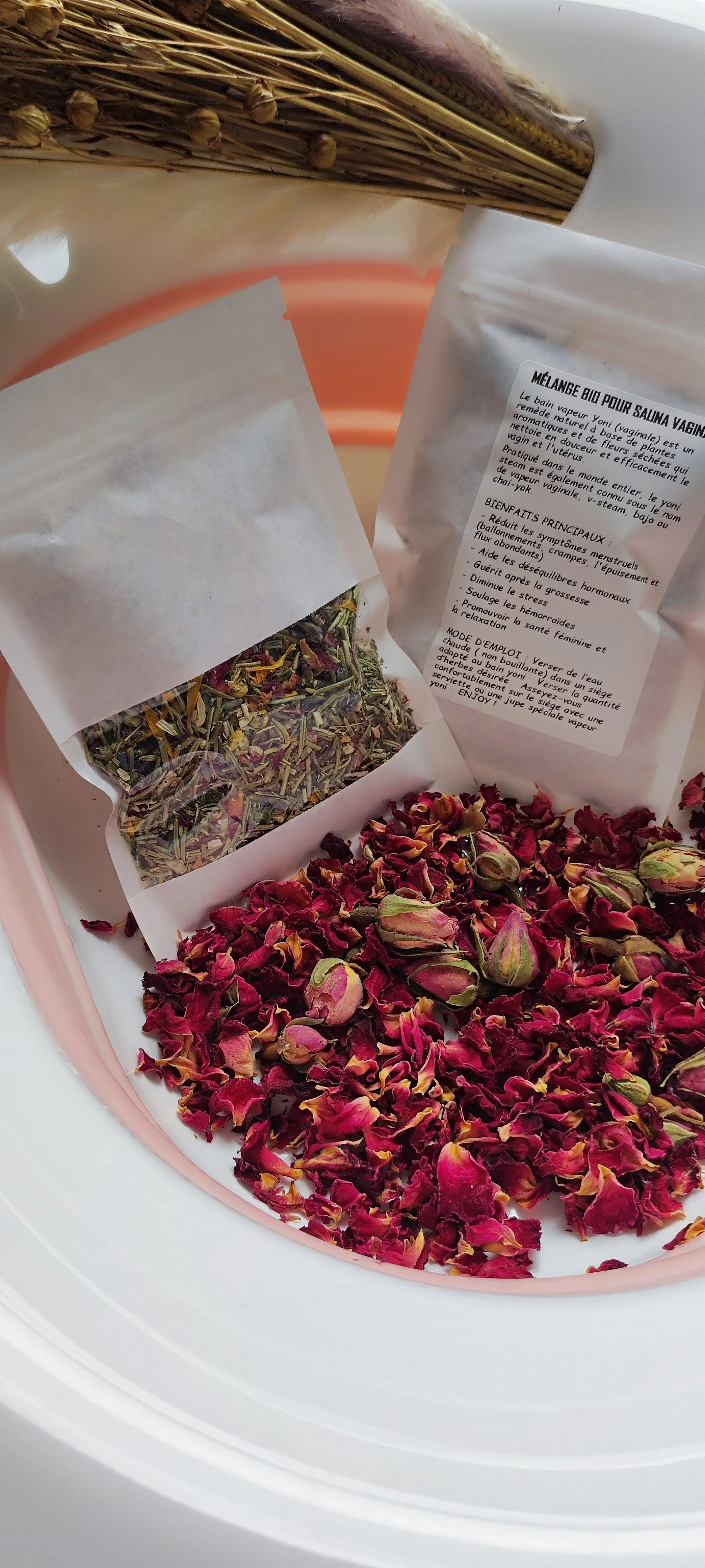 Fleurs de rose séchées, un sachet de mélange bio pour salina vaginal, et une infusion de plantes.
