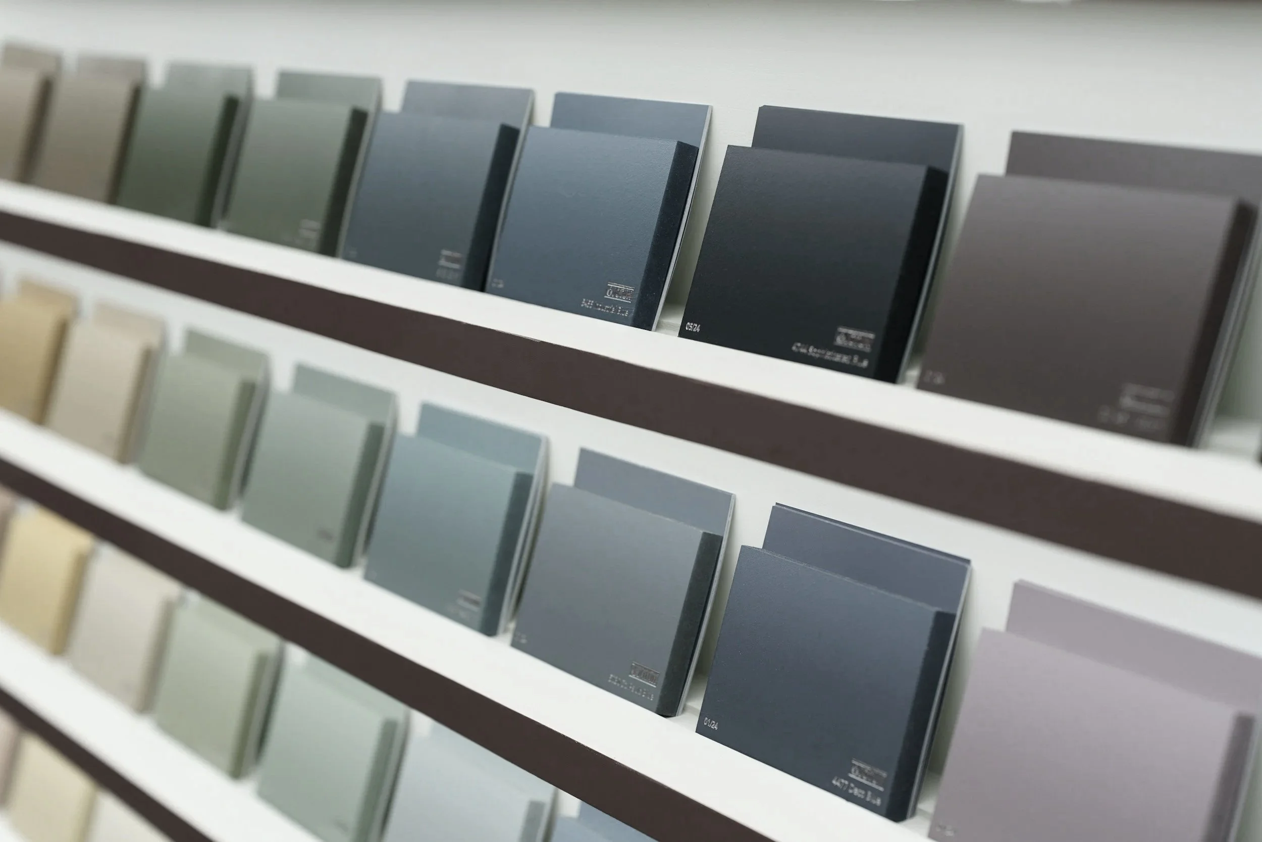 Color samples or paint swatches displayed on a multi-tiered shelf.