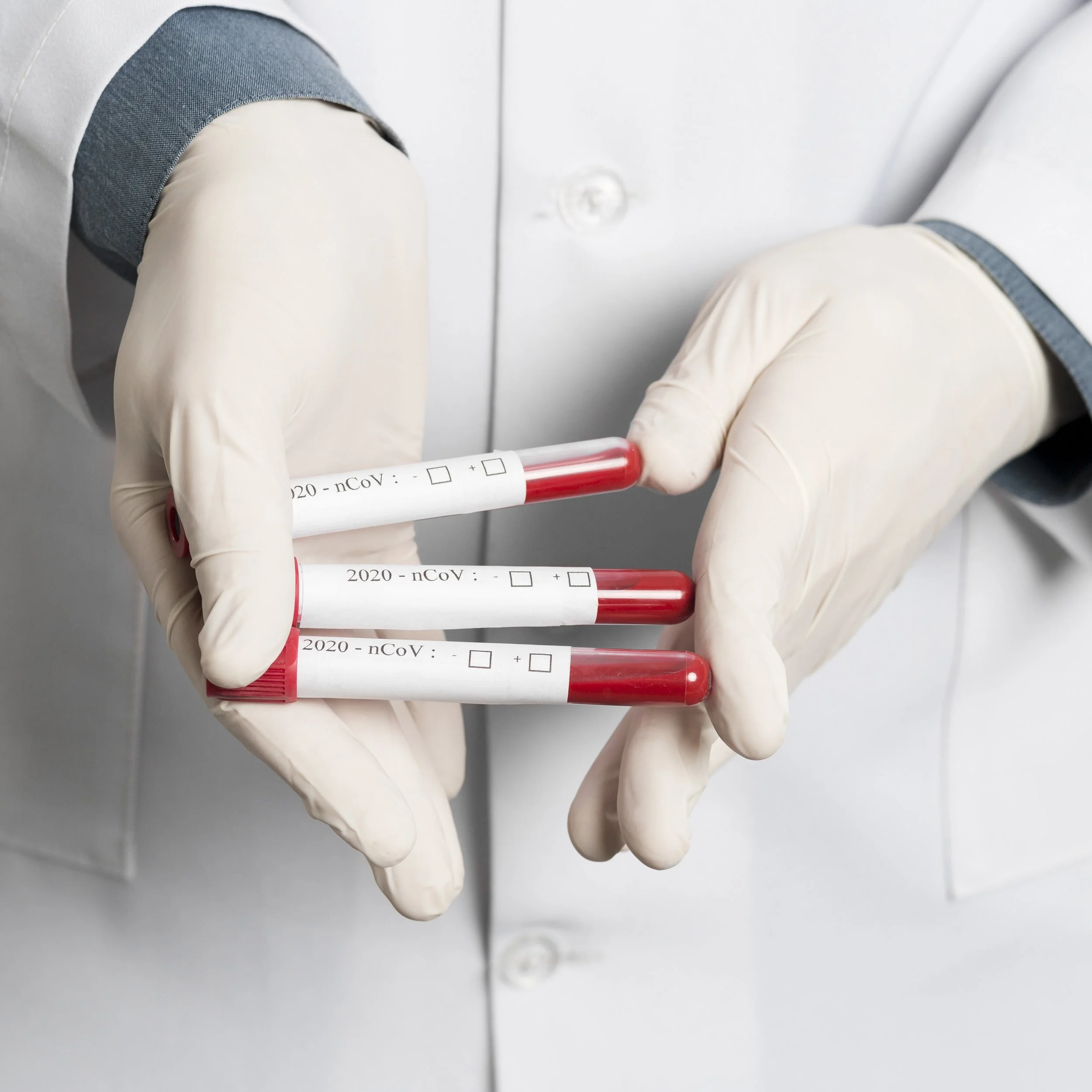 Logo for Freedom Mobile Lab featuring a stylized stethoscope, blood drops, a satellite dish, and a heartbeat line over a blurred background of test tubes.