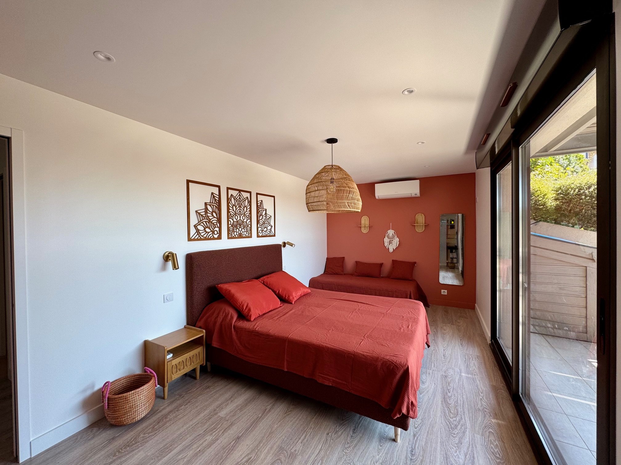 Chambre Alessio moderne avec lit 160, grande fenêtre  coulissante donnant sur le jardin et la piscine. Petite banquette teracotta.