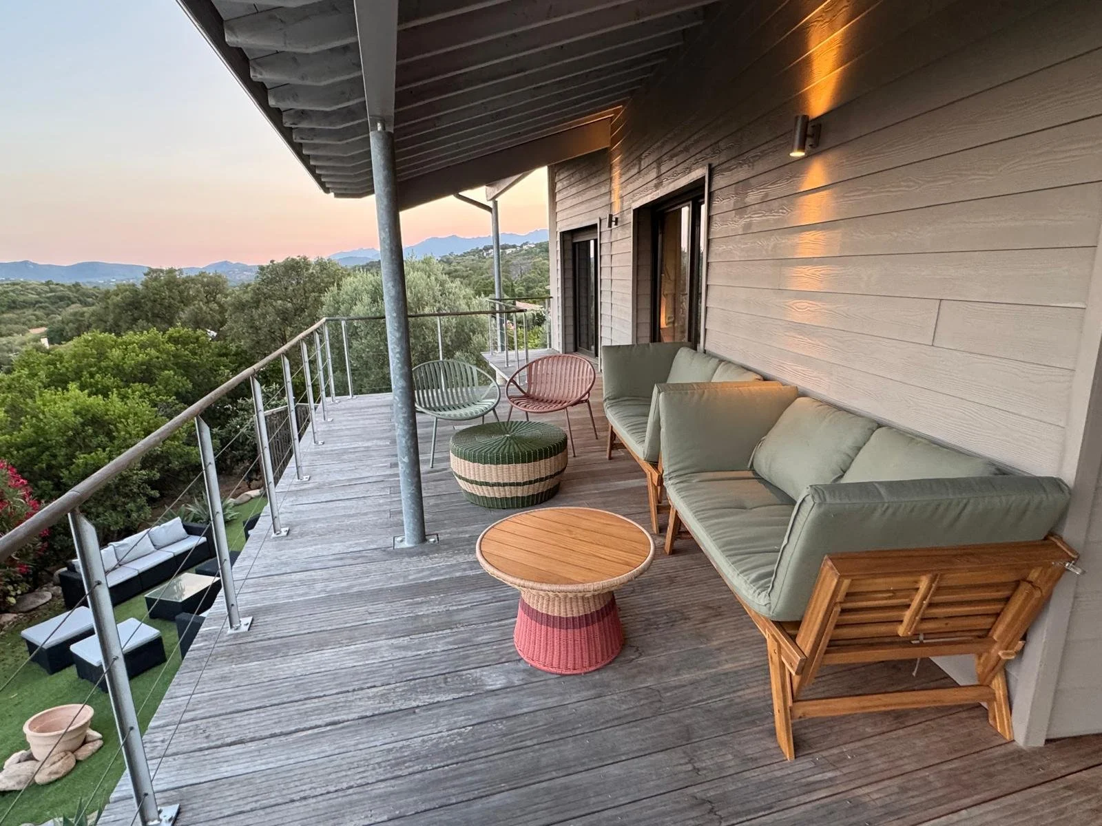 Espace salon extérieur sur la terrasse avec deux canapés, 4 fauteuils et deux tables basses.