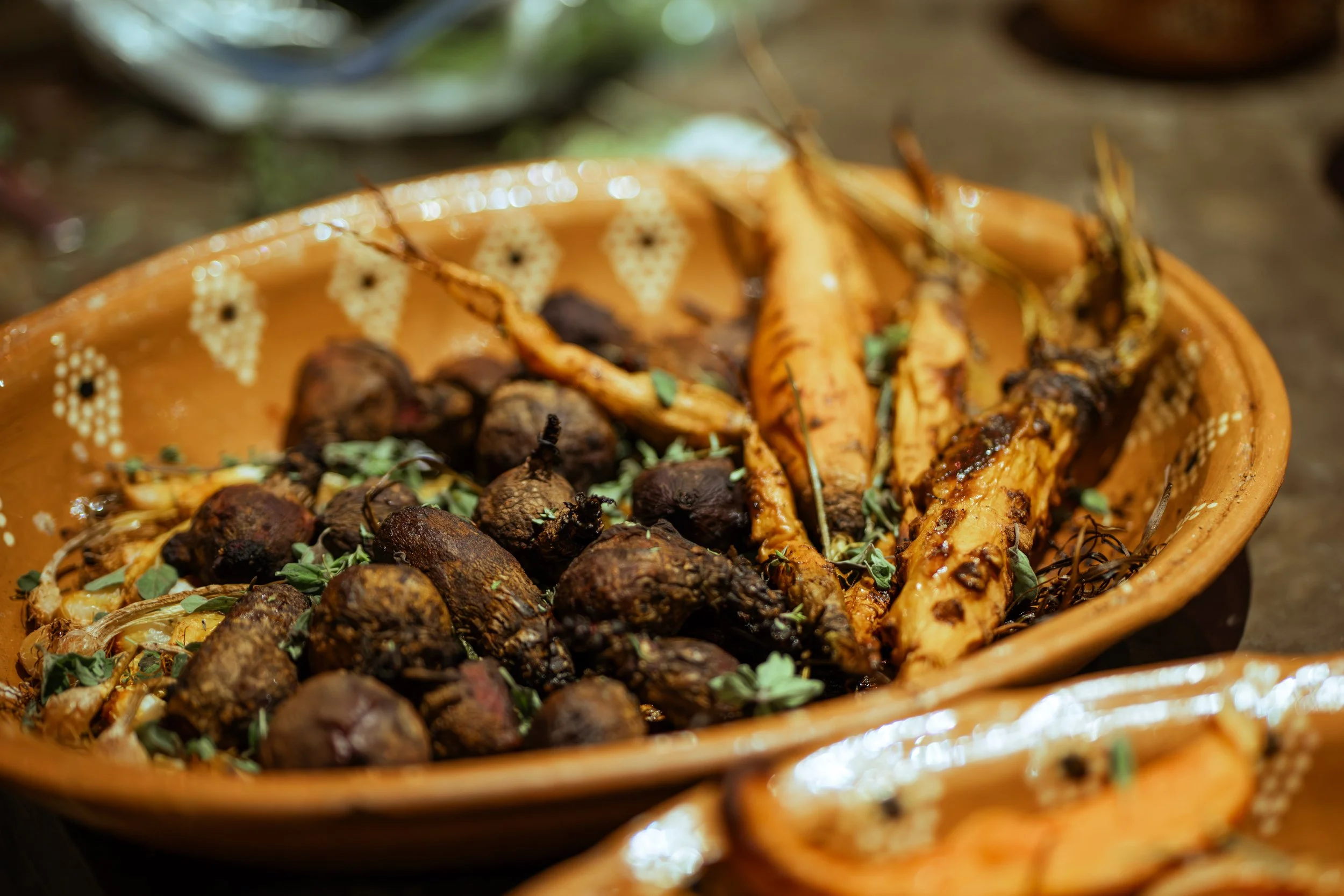 A traditional Mexican ceramic platter filled with roasted corn and truffles garnished with herbs.