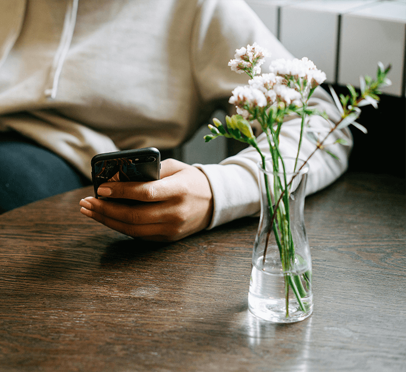 woman on her phone with flowers