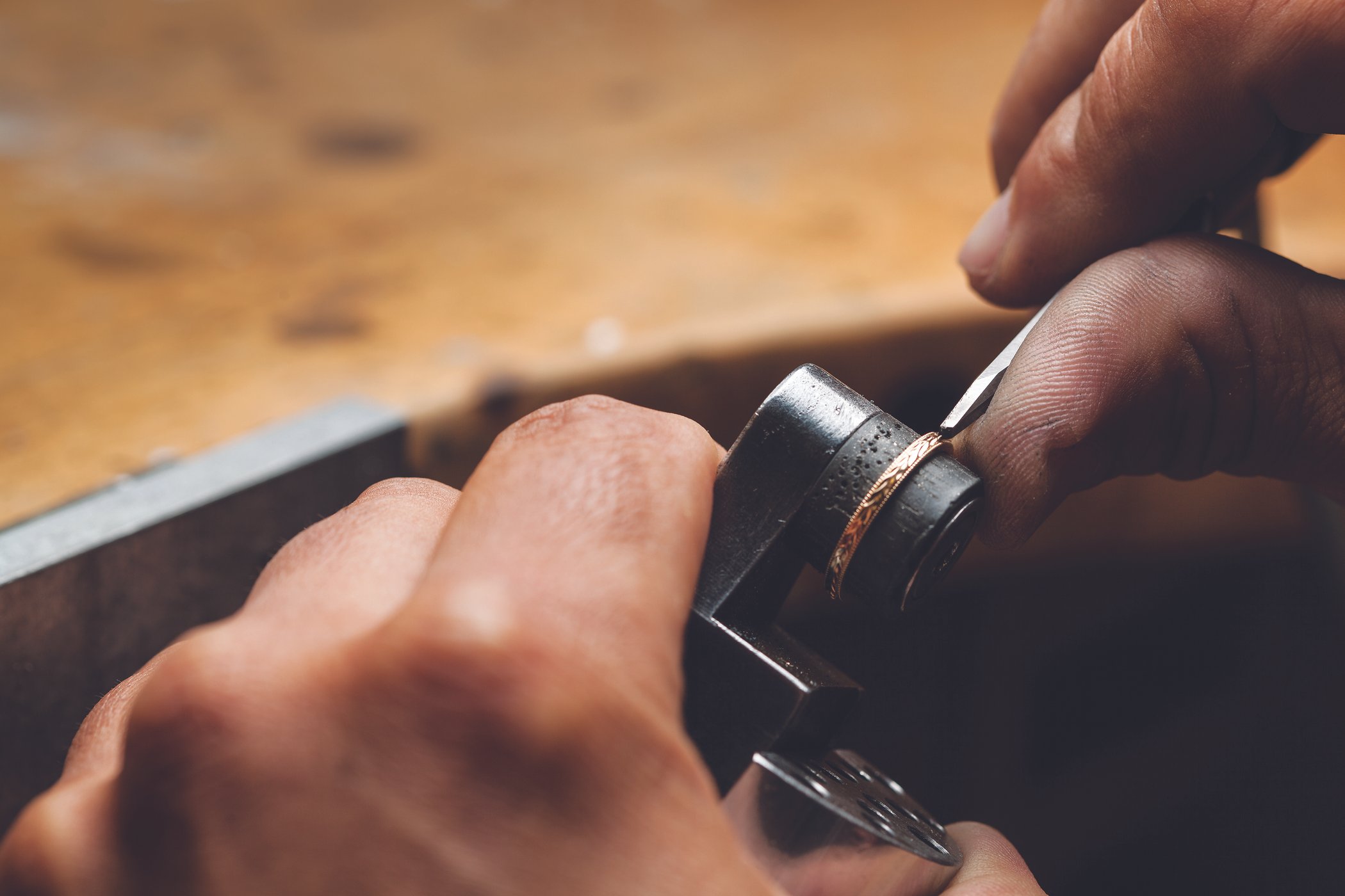 Our Master Jewelery applying hand engraving to a wedding band.