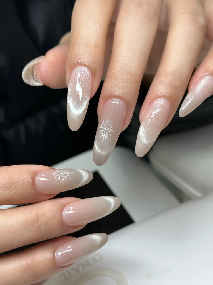 Iris nail art at Serene Nail Club NYC: Glossy almond nails with white snowflakes