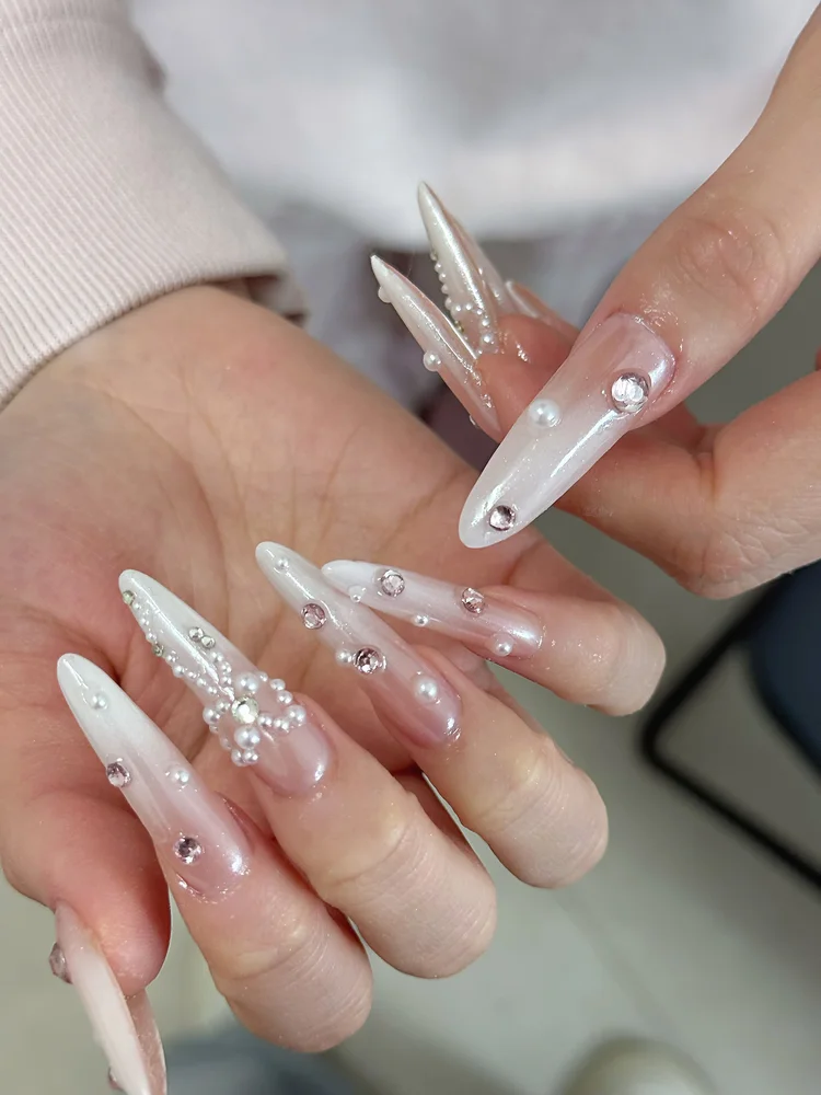 Iris nail art: Long nails embellished with pearls and rhinestones
