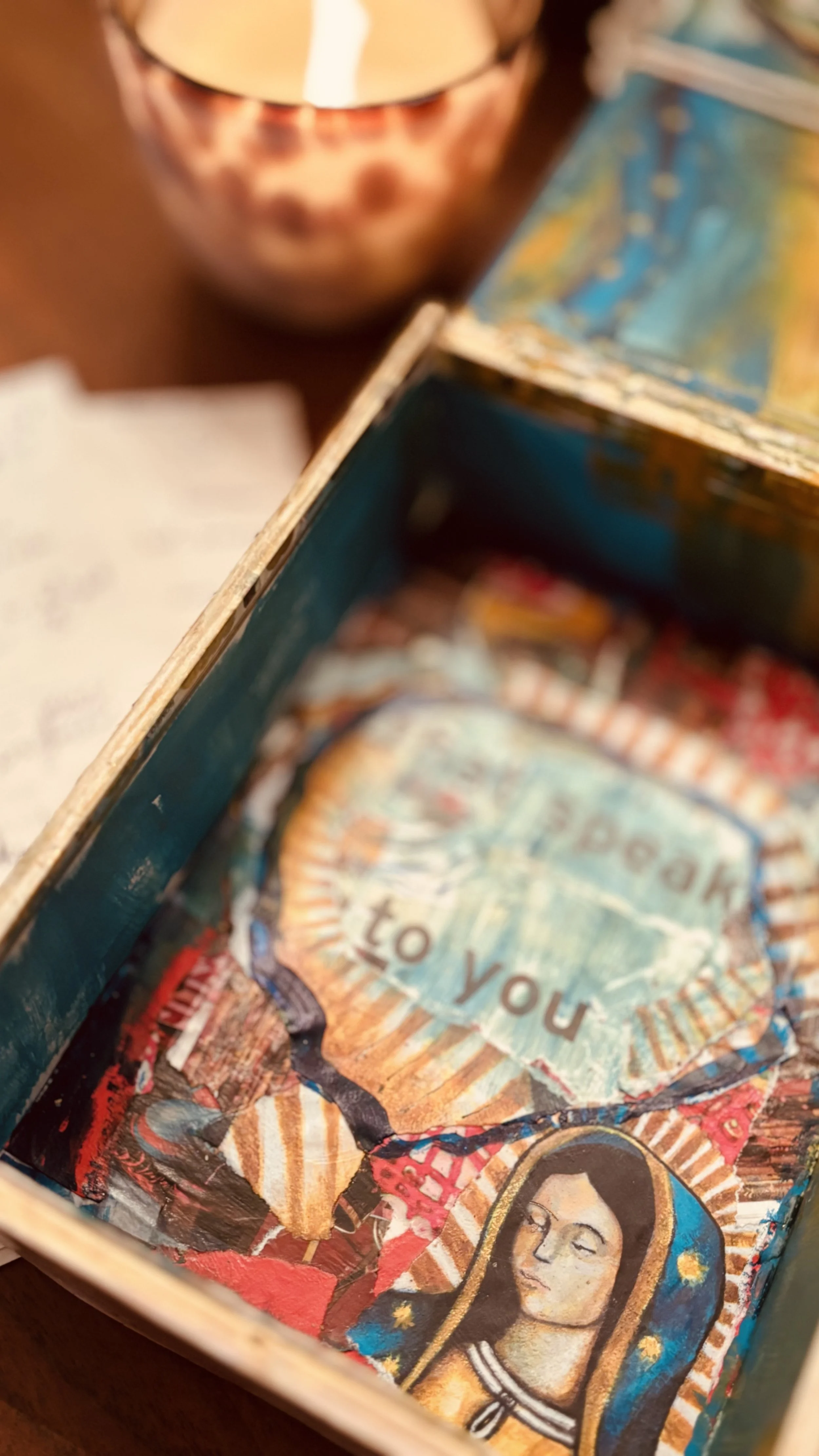 Close-up image of a colorful, layered collage inside a box with the words 'Thank you' and a portrait of a woman with long dark hair wearing a striped top.