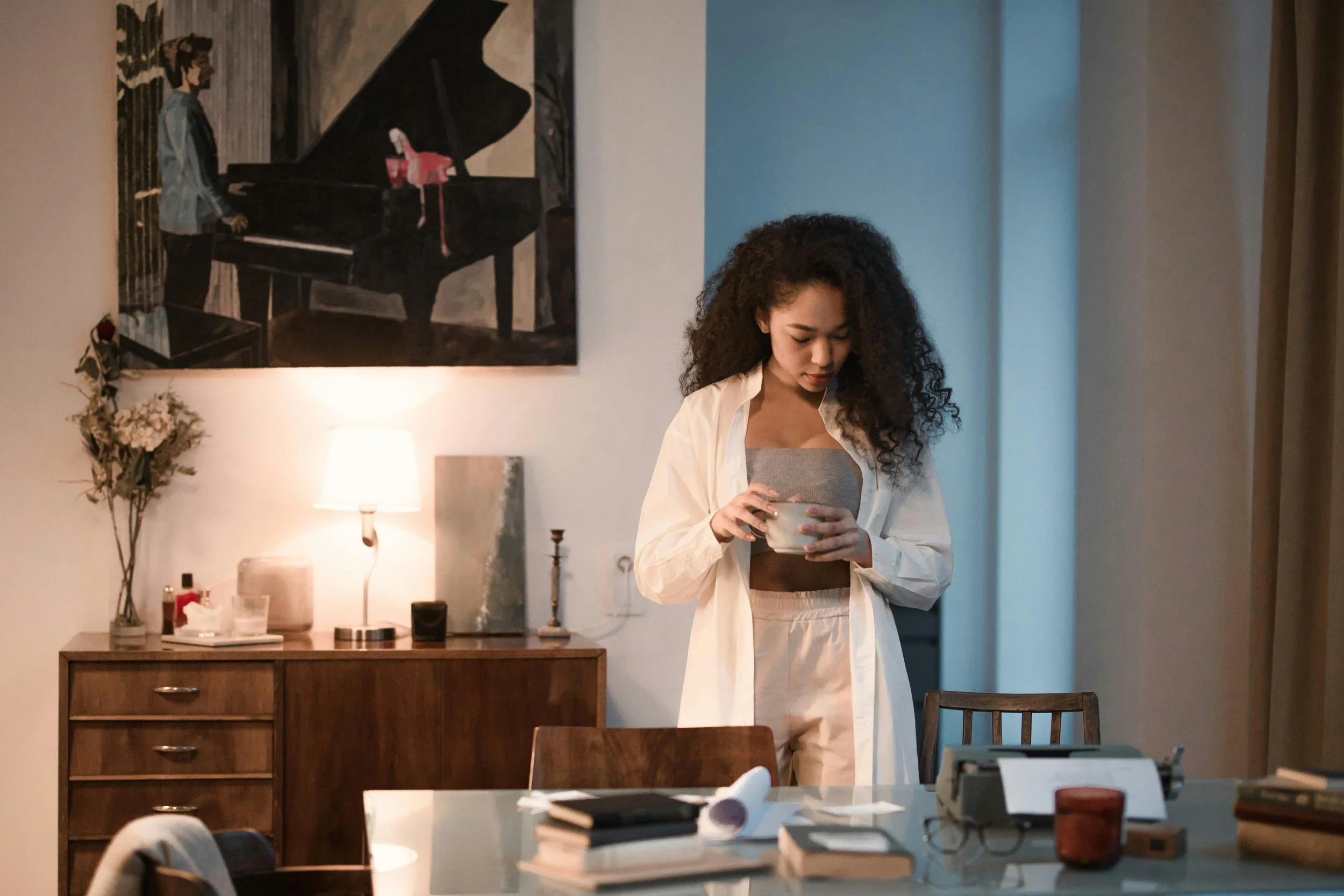A woman holds a mug and looks down in a quiet kitchen moment, the kind of pause where unwelcome thoughts often surface.