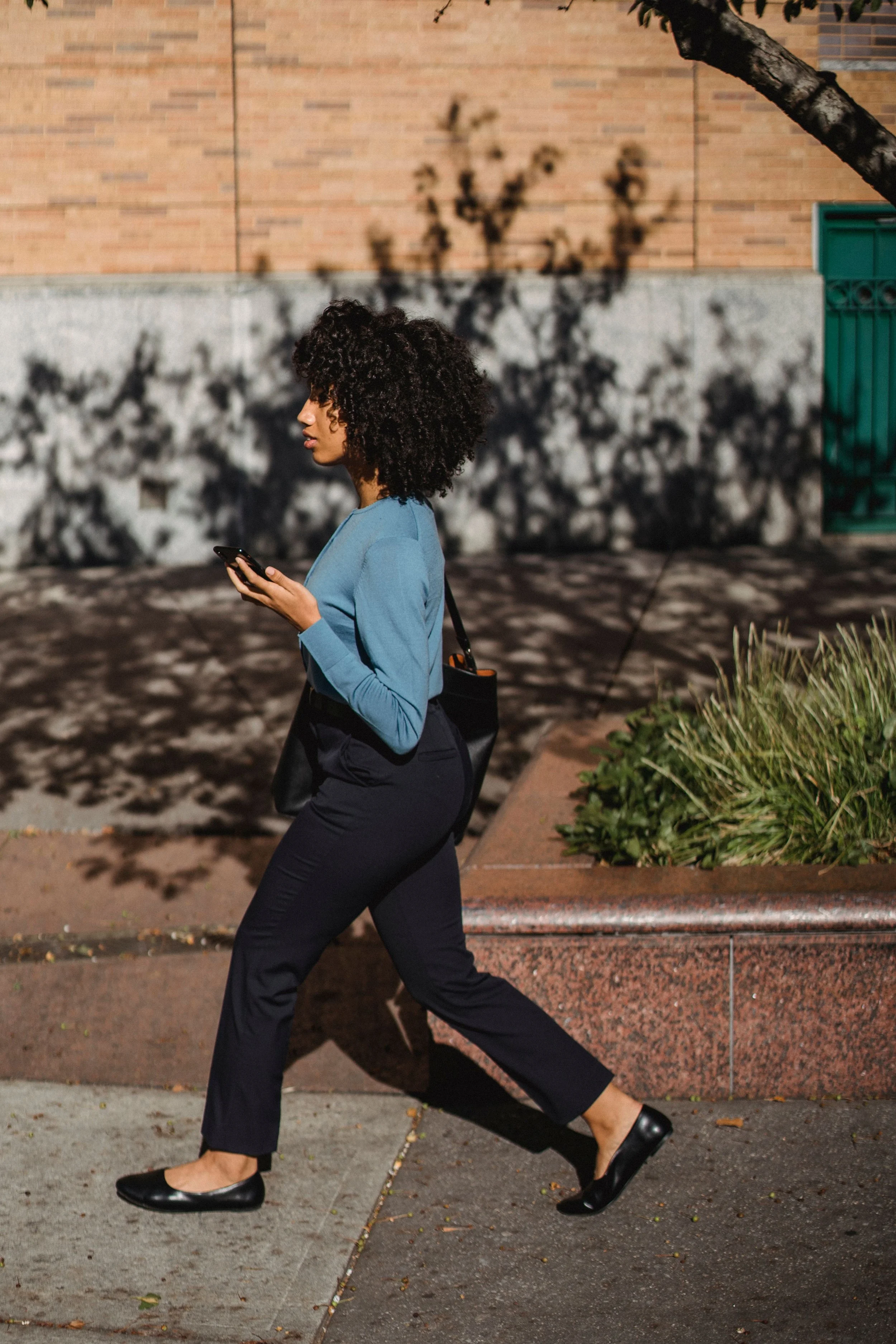 A woman walks down a quiet sidewalk alone, the kind of walk women take when they are working something out without telling anyone.