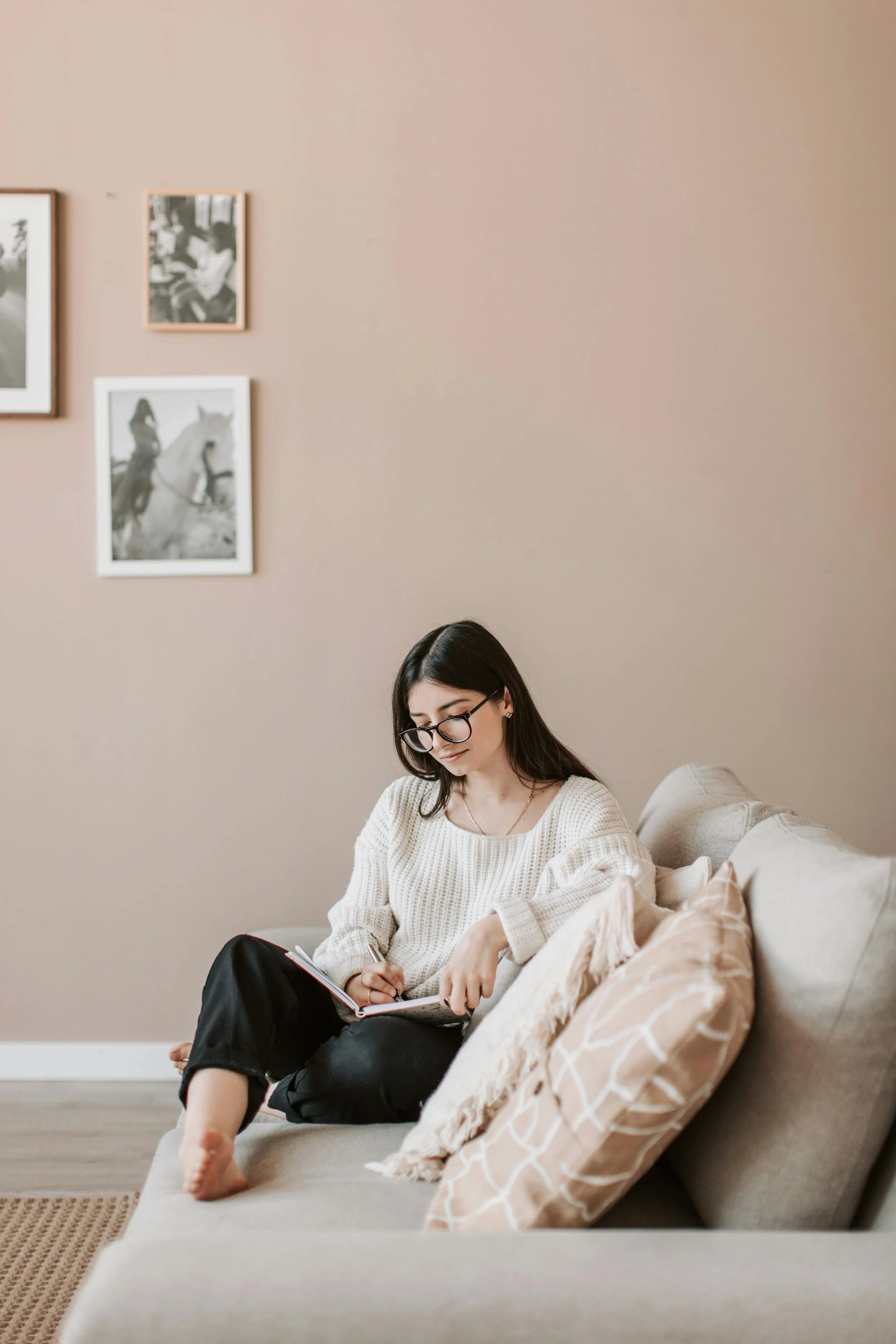 Woman writing in a journal on a couch during trauma therapy in Madison, Wisconsin