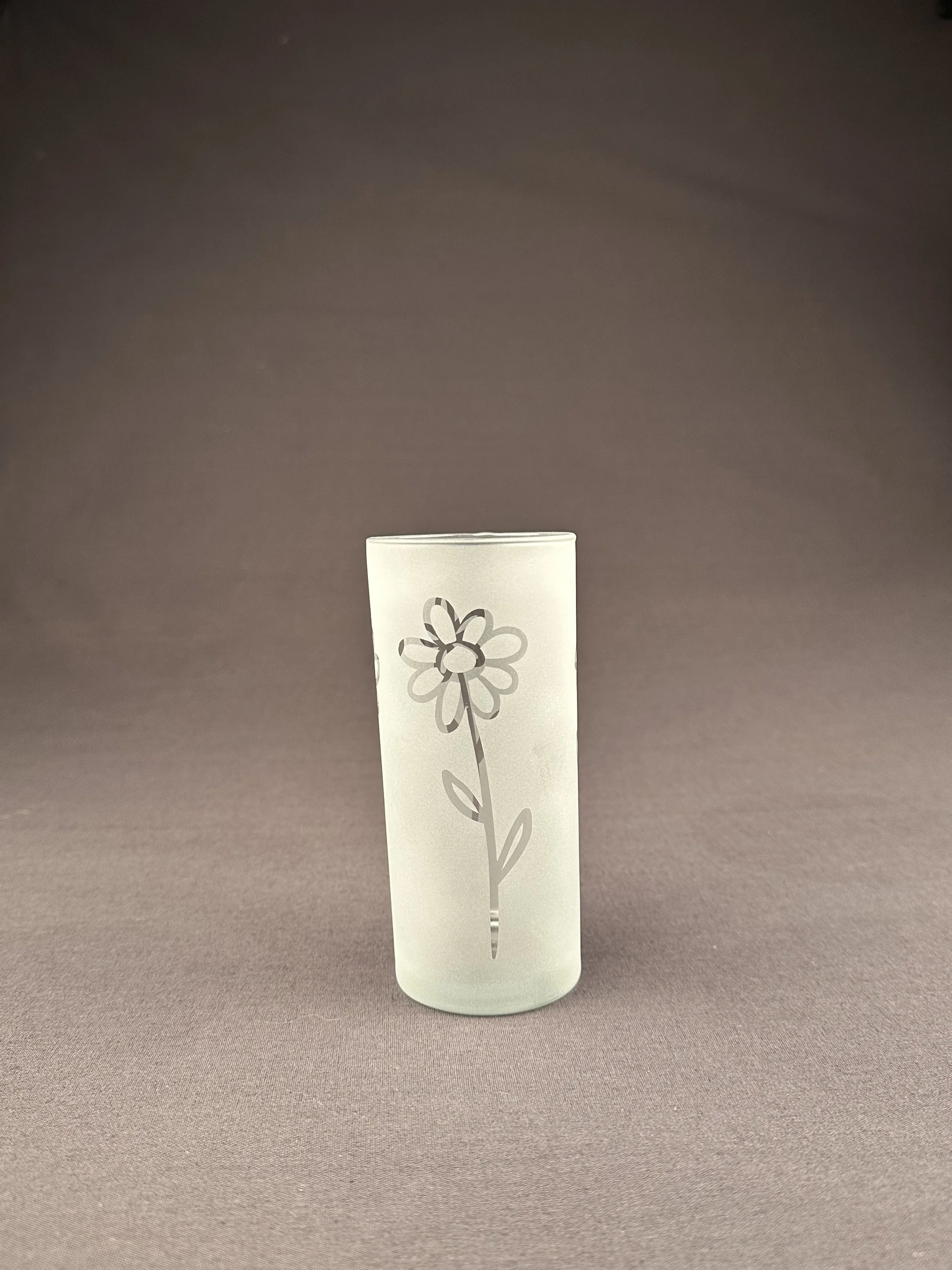 Kleine Milchglas mit einem aufgemalten Blumenmuster, auf neutrager Hintergrund.