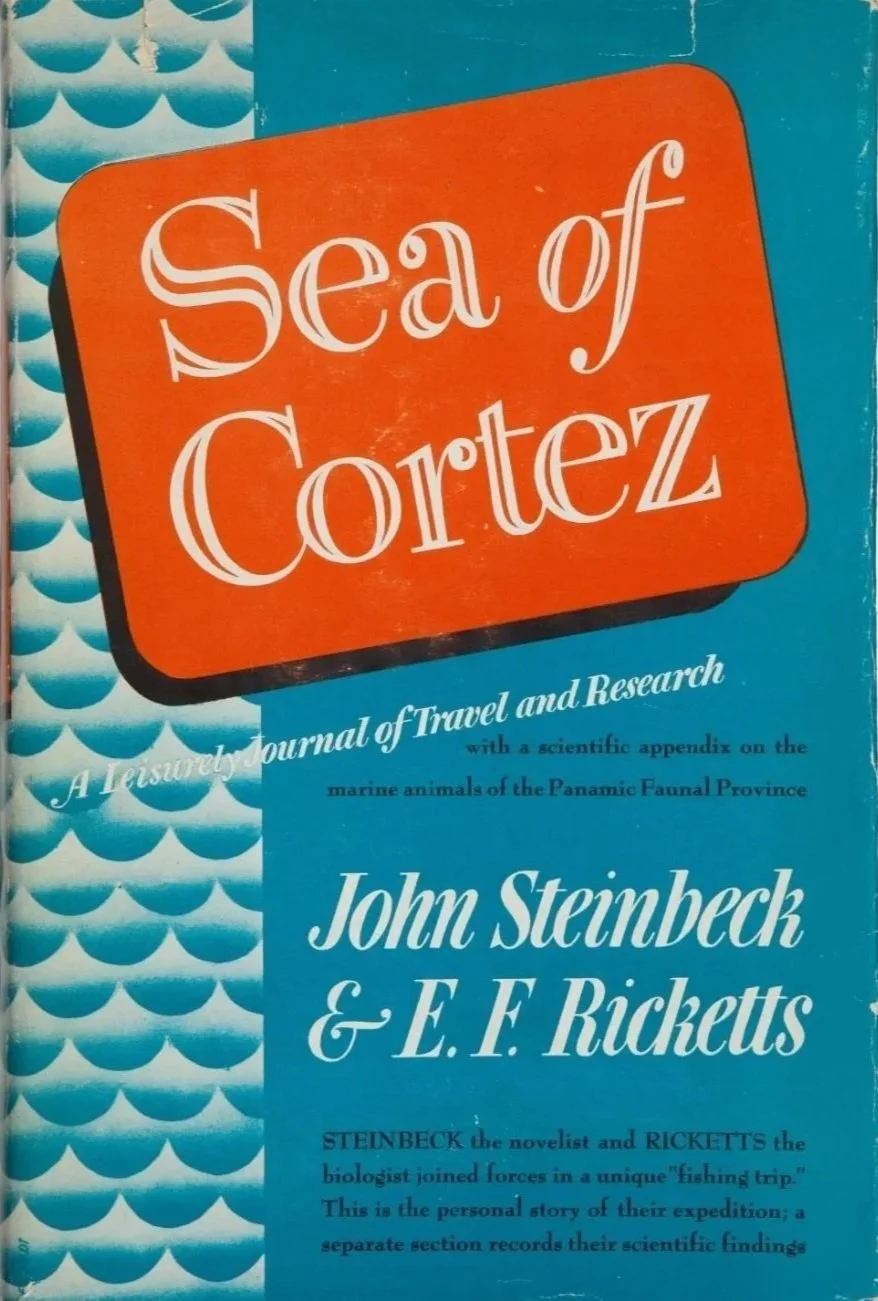 Book titled 'Sea of Cortez' by John Steinbeck & E. F. Ricketts, with a blue and orange cover and wave pattern on the left side.