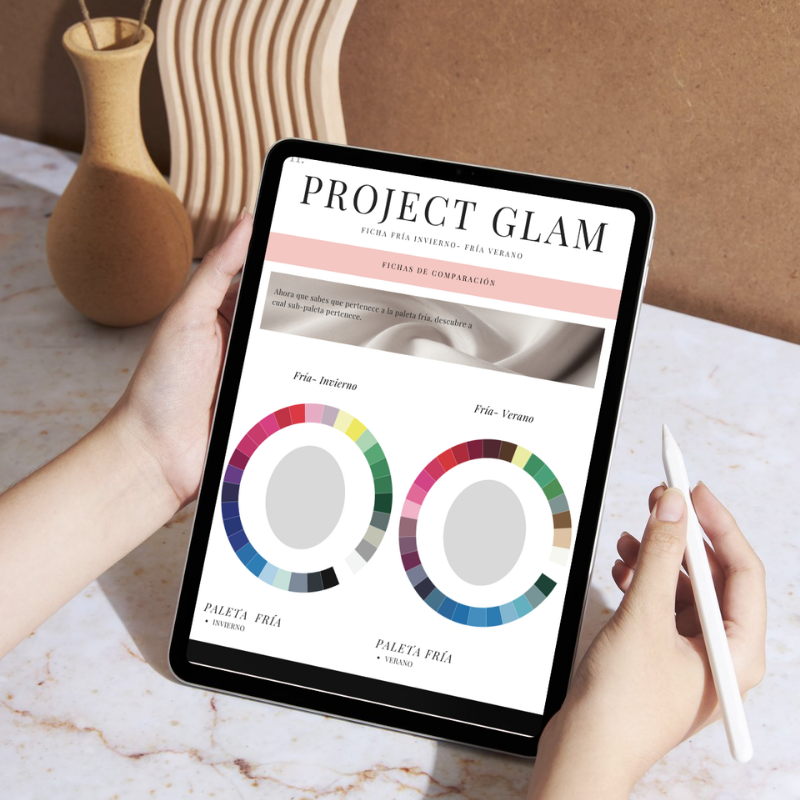 Pantalla de una tableta que muestra un proyecto llamado 'PROJECT GLAM' con gráficos de comparación de paletas de colores para invierno y verano, sobre una mesa con un jarrón y una silla de madera.