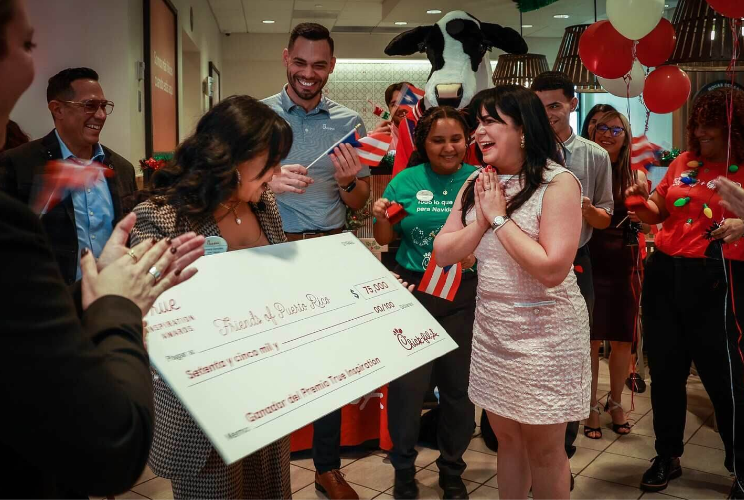 Angelique Sina, president of Friends of Puerto Rico, is recieving  a large check for $75,000 from Chick-fil-a.