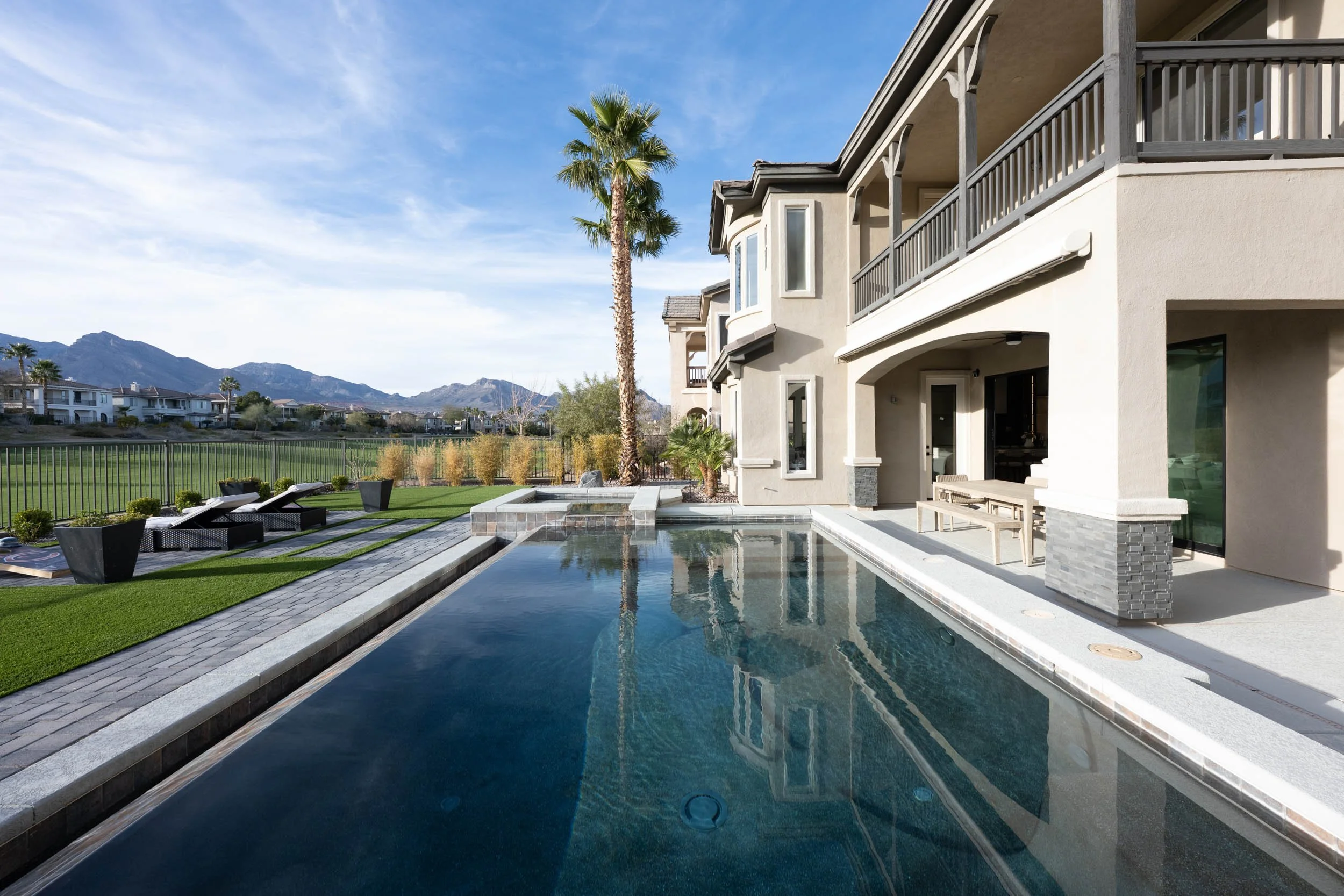 Modern house with a private swimming pool, outdoor seating, and a mountain view in the background.