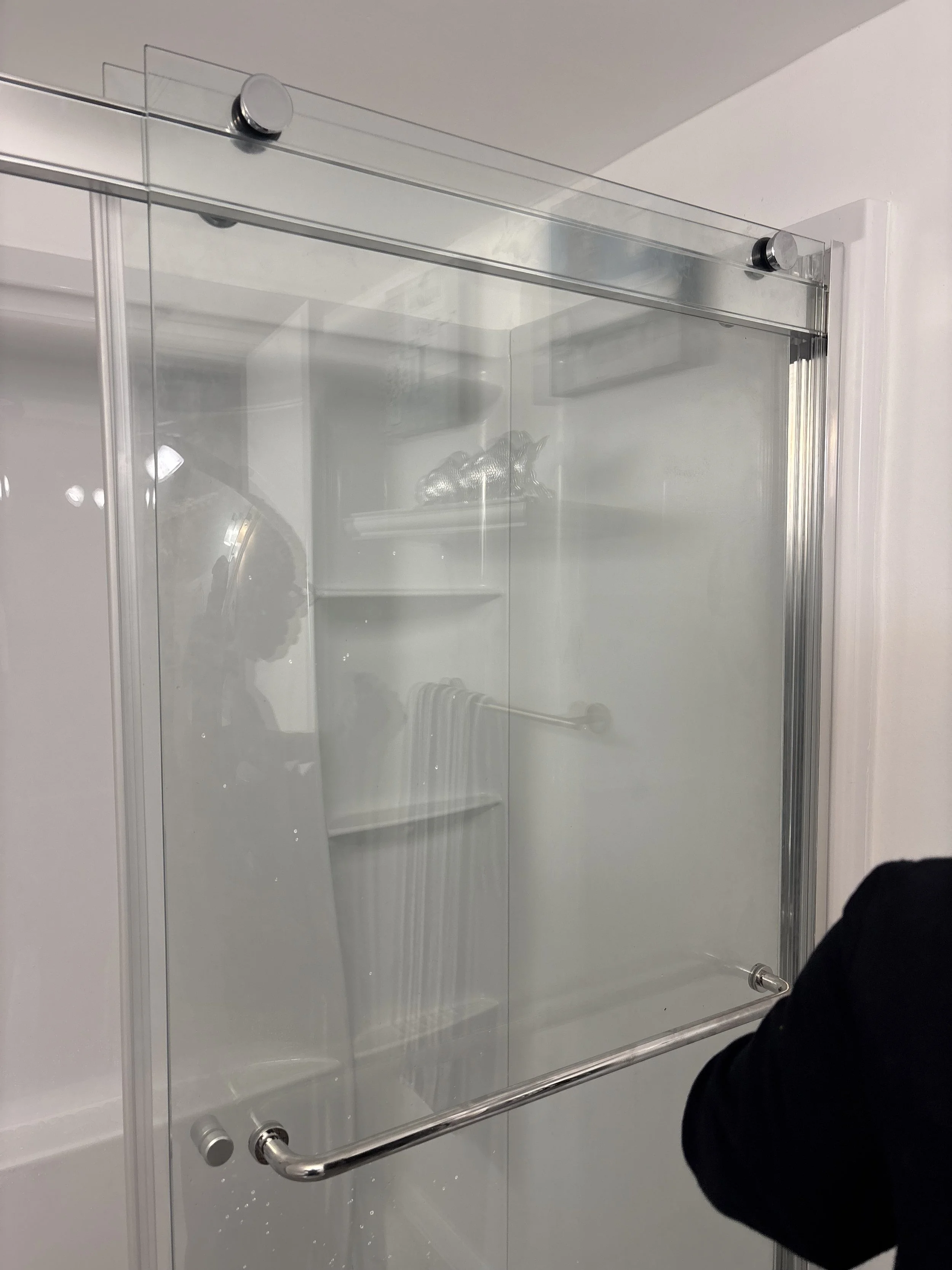 A glass shower door with metal hardware. 
