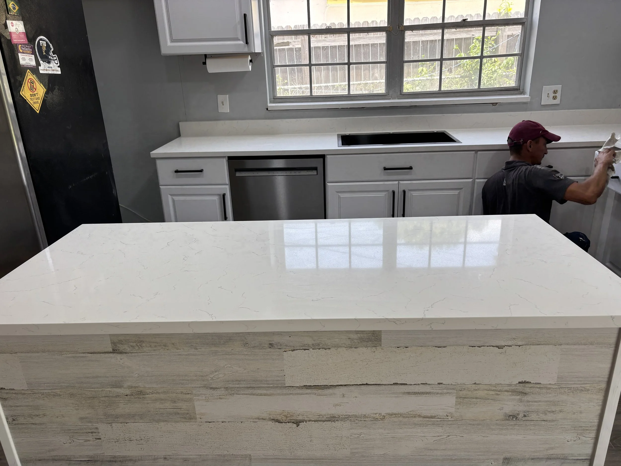 Kitchen with our crew putting the finishing touch to the Quartz countertop.