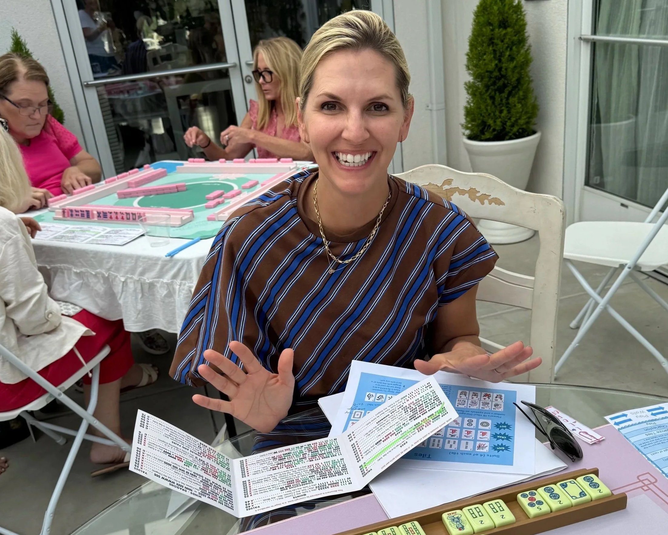 A woman playing Mahjong and having fun! Mahjong! She is practicing Mahjong in her Guided Play Class. She wins every time! Mahjong instructor/classes/instruction near me.