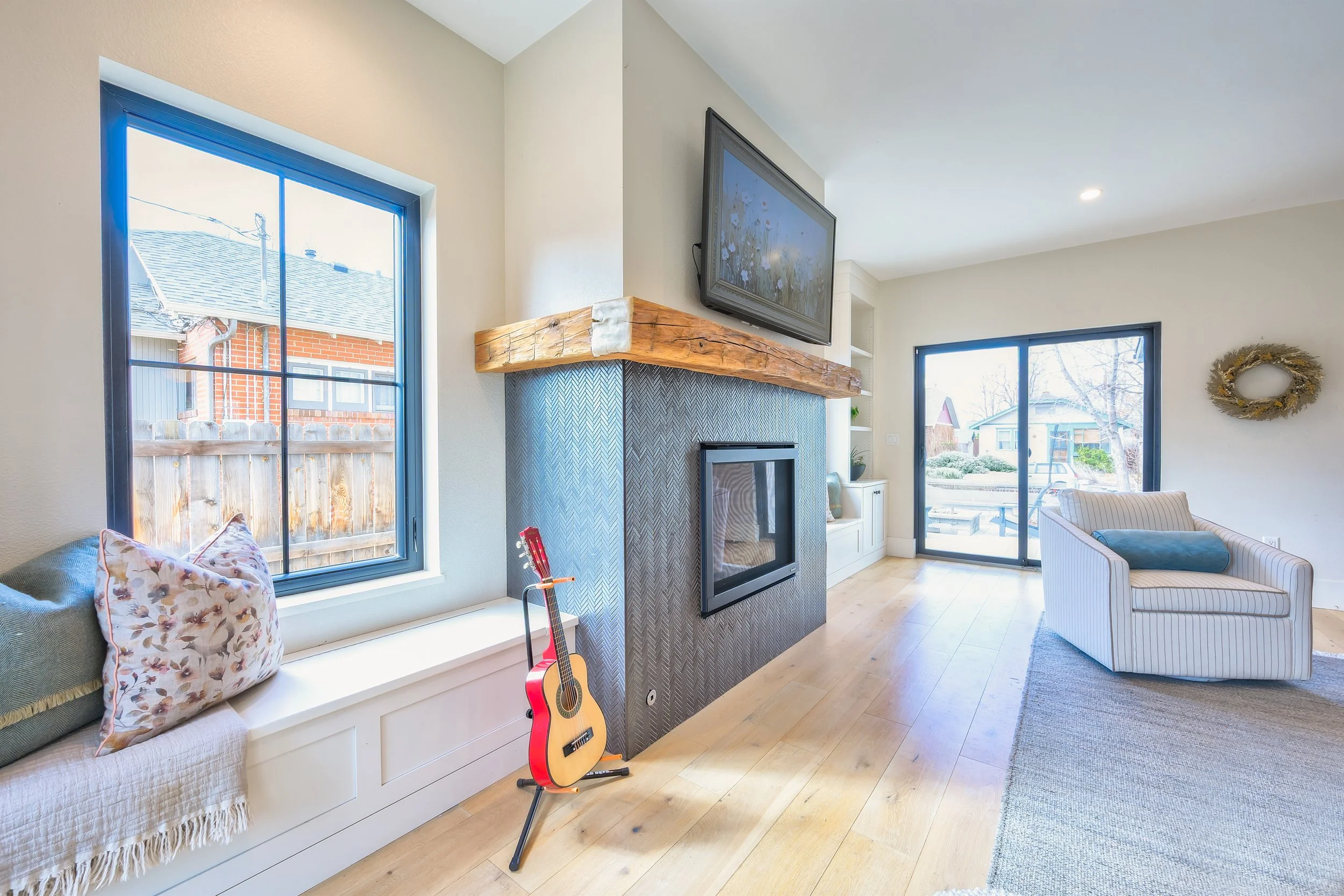 Chevron tiled fireplace with reclaimed beam mantel, custom built window seats. 
