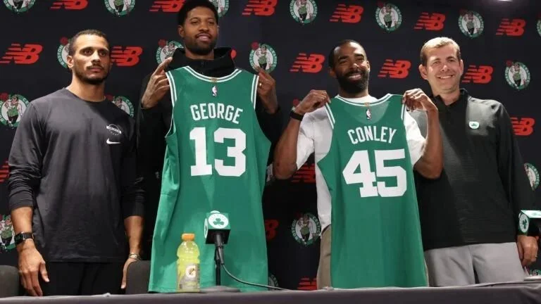 Paul George and Mike Conley hold Boston Celtics jerseys beside Joe Mazzulla and Brad Stevens