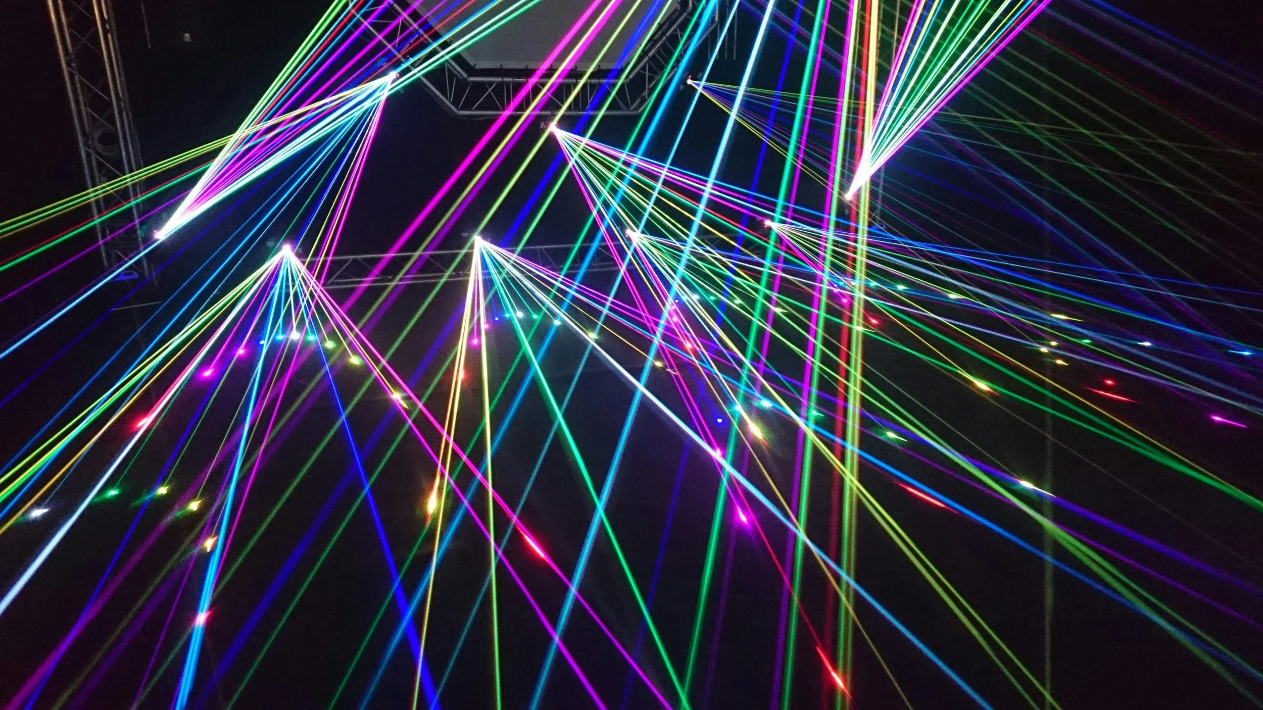 Colorful laser lights creating an abstract pattern against a dark background.